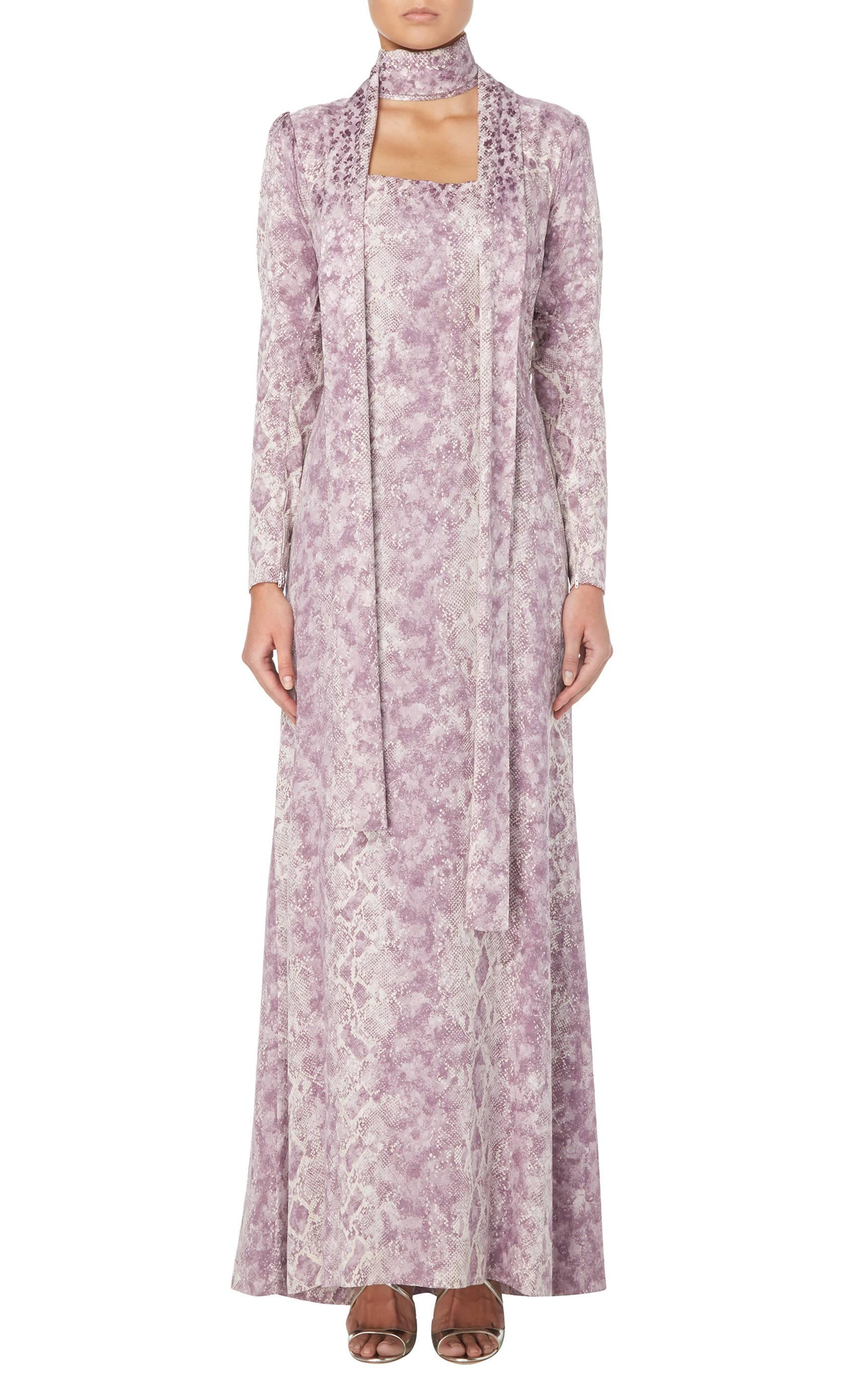 A beautiful and dramatic piece of haute couture by the great Yves Saint Laurent, this exceptional dress is made of pure silk, printed with a python skin pattern in lilac upon a rich ivory background. Gently shaped and darted at the waist to enhance