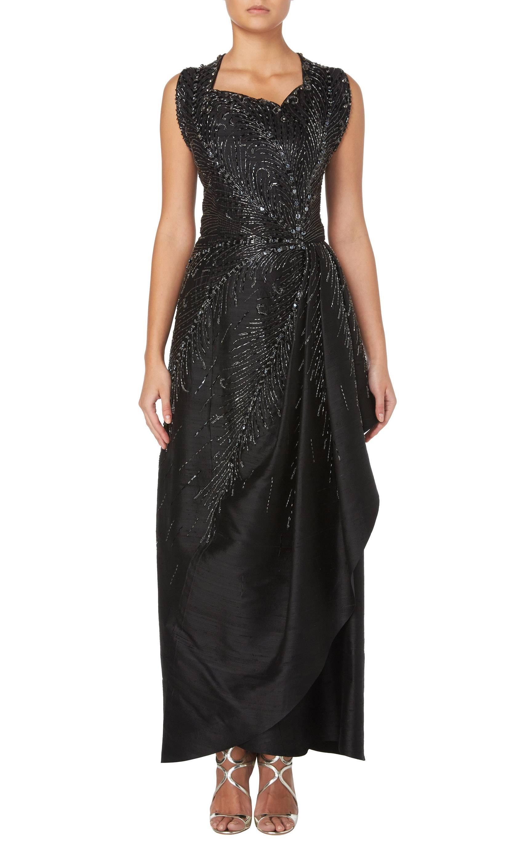 A spectacular piece of haute couture by the Parisian couturier Bruyere, this gown is strikingly modern and darkly glamourous, perfect for a Black Tie or Red Carpet event. Crafted in black raw silk, the dress is entirely covered with finely