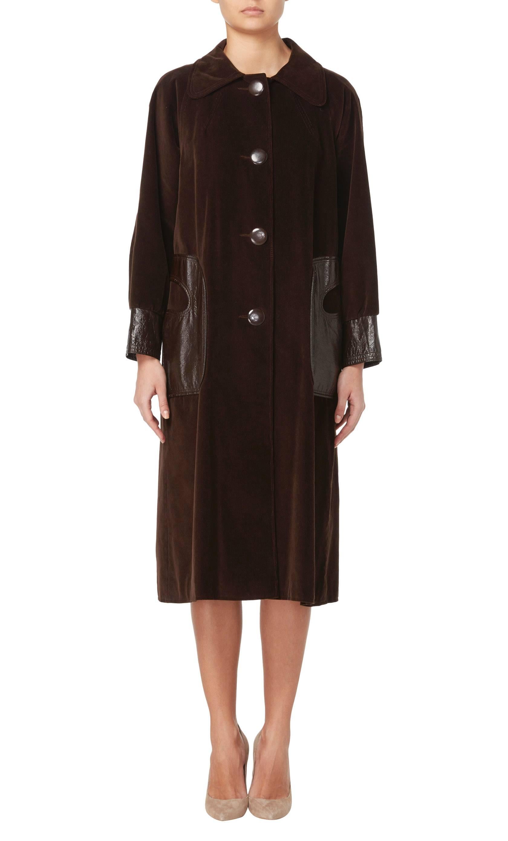 This Pierre Cardin coat is an amazing piece! Constructed in brown corduroy, the coat features an exaggerated collar and fastens to the front with overscale buttons. The pockets and cuffs are in a contrasting brown patent leather, while a wool lining