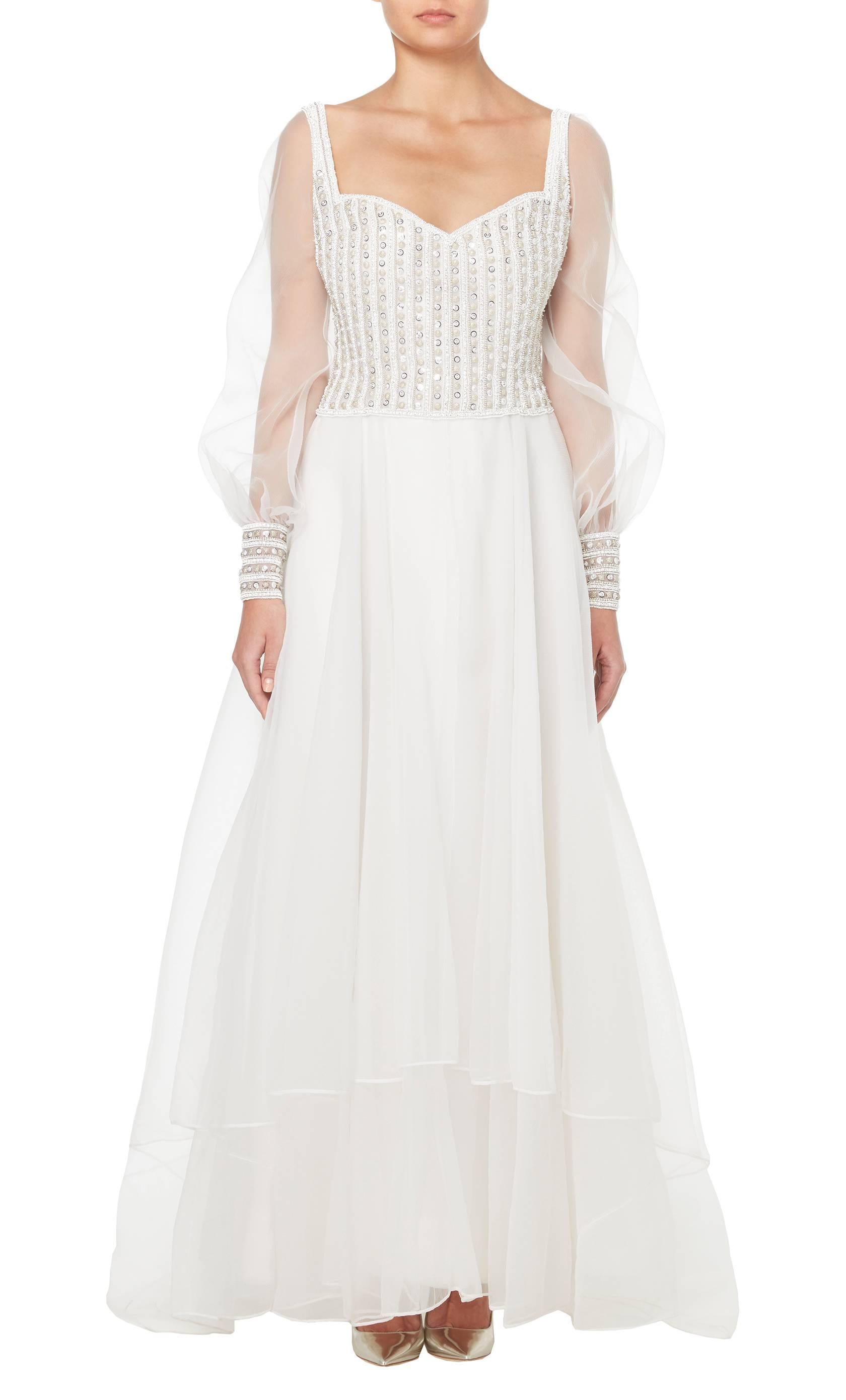 This stunning Dior wedding dress and floor length veil is constructed in pure white cigaline silk and silk tulle. The dress is set with sparkling Swarovski crystals to the bodice, cuffs and capped veil and is the perfect, romantic dress for such a