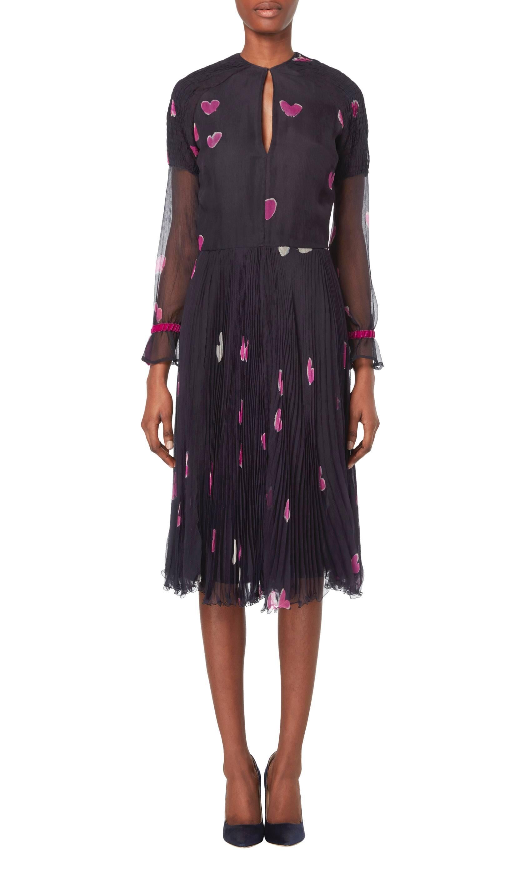 This beautiful Thea Porter couture dress features a romantic pink heart print by the textile artist Hannah Meckler. Constructed in dark blue silk chiffon, the dress features smocking on the shoulders and keyhole cutout on both the front and back.
