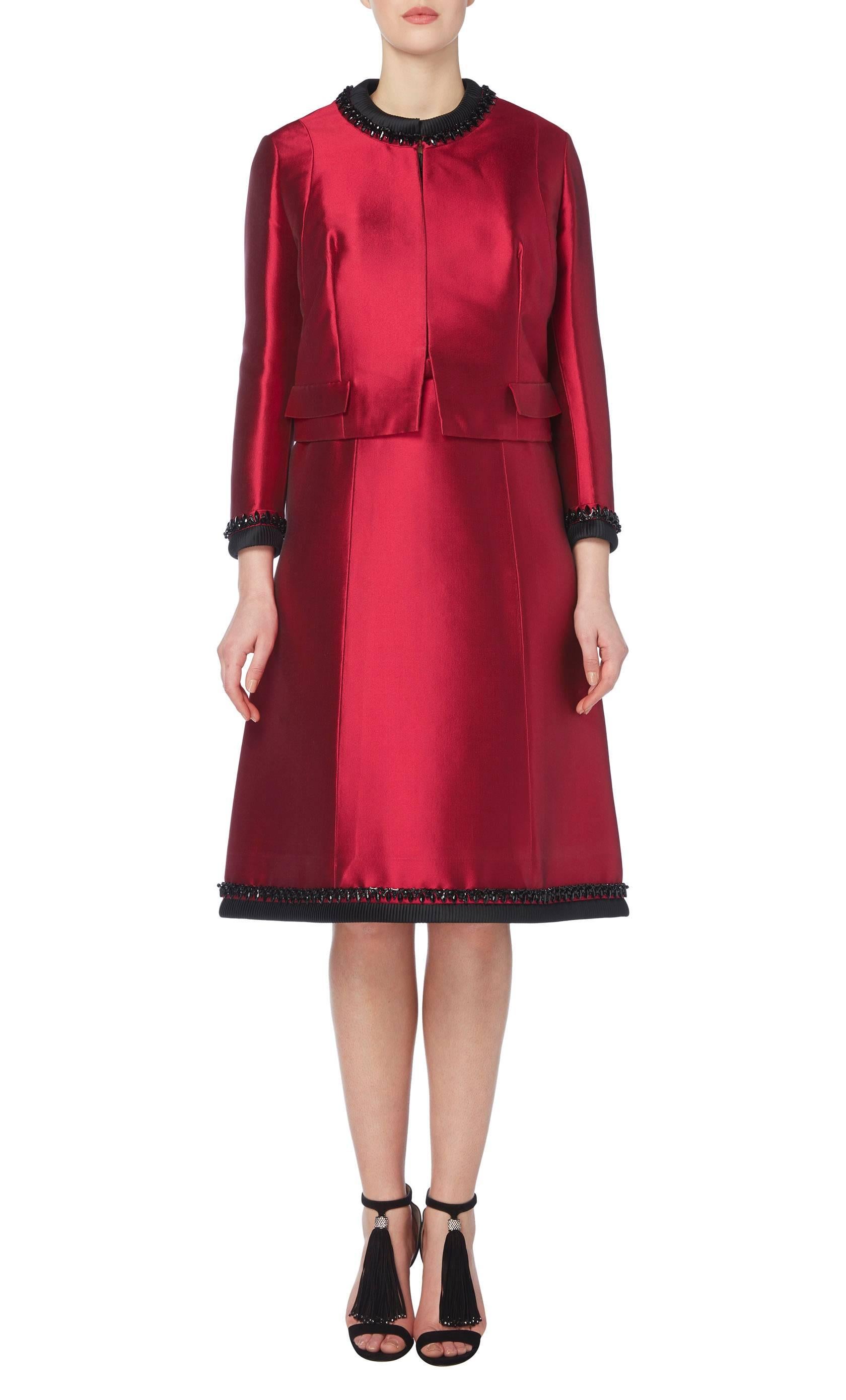 A beautiful piece of haute couture, this Balmain dress suit is ideal for cocktail events or special occasions. Constructed in a stunning shade of raspberry silk, the dress and jacket feature matching black ribbed trimming with jet beading
