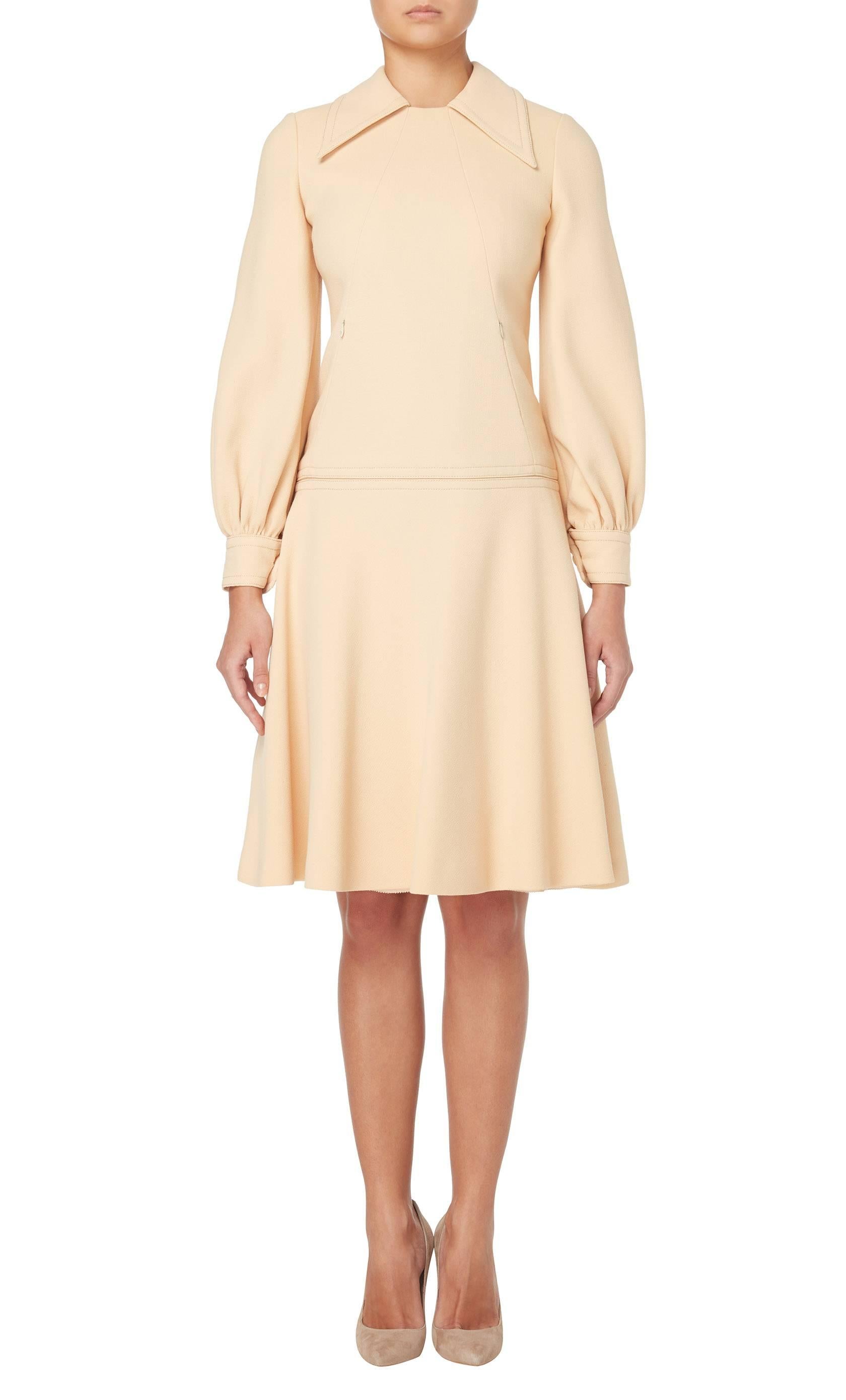 Constructed in apricot coloured wool, this dress will work for the office and daytime occasion alike. Featuring an exaggerated collar and long sleeves, the dress has a drop-waist silhouette and a wide skirt. Zip pockets sit on the waist while the