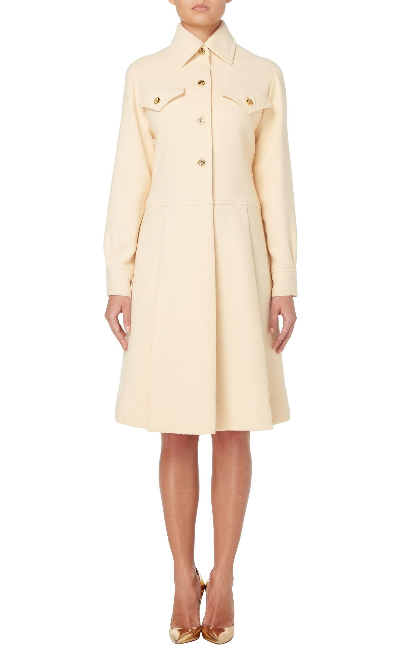 This Galanos dress would make a great option for the office. Constructed in ivory wool, the dress gives the illusion of being a coat, with a single lapel collar and snakeskin effect buttons fastening to the front, chest pockets and cuffs. The