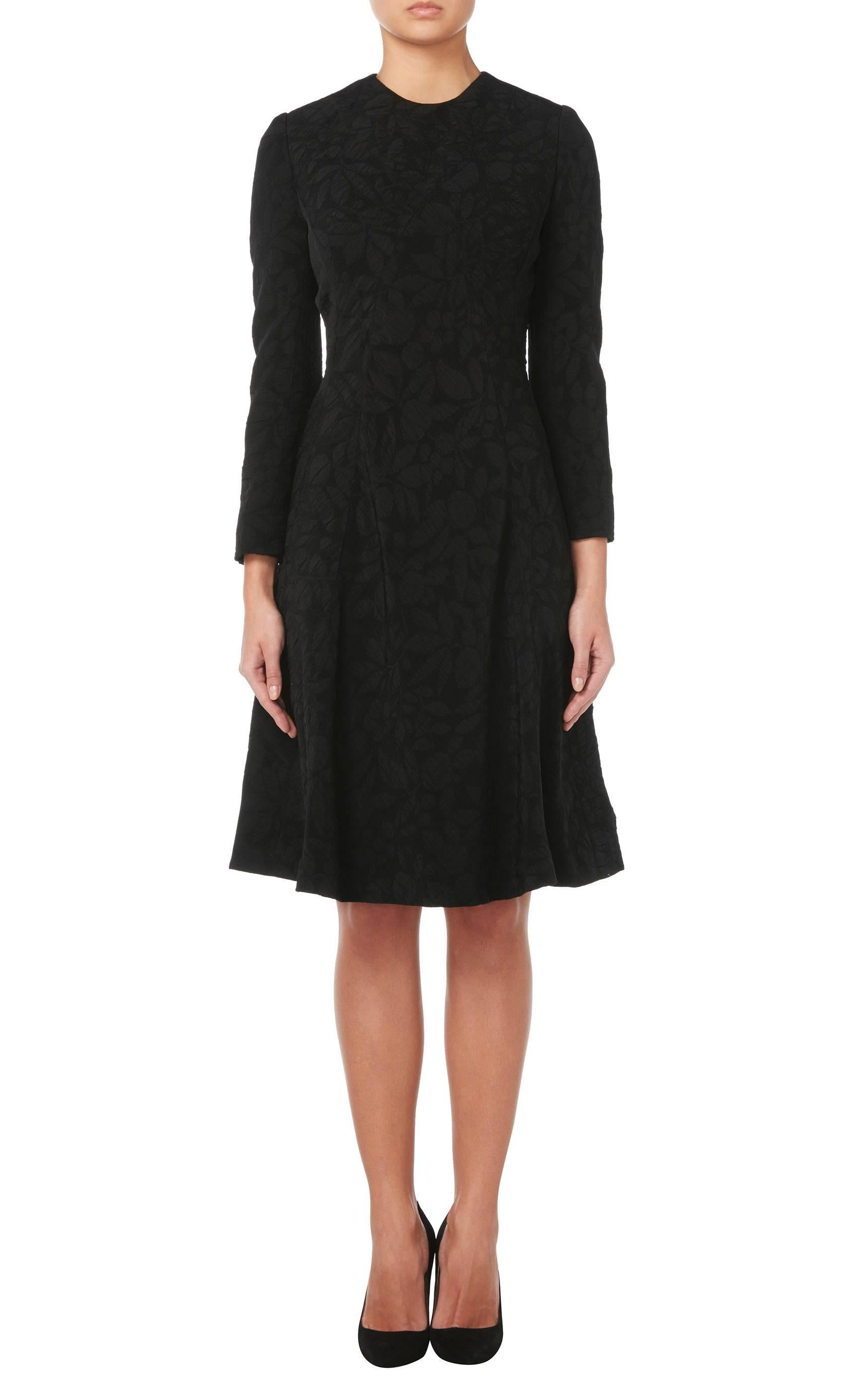 A little black dress is a wardrobe essential and this beautiful Galanos dress will make a timeless addition to any wardrobe. Constructed in black matelasse silk, the dress has a round neckline and long sleeves, with a close fitting bodice and flared