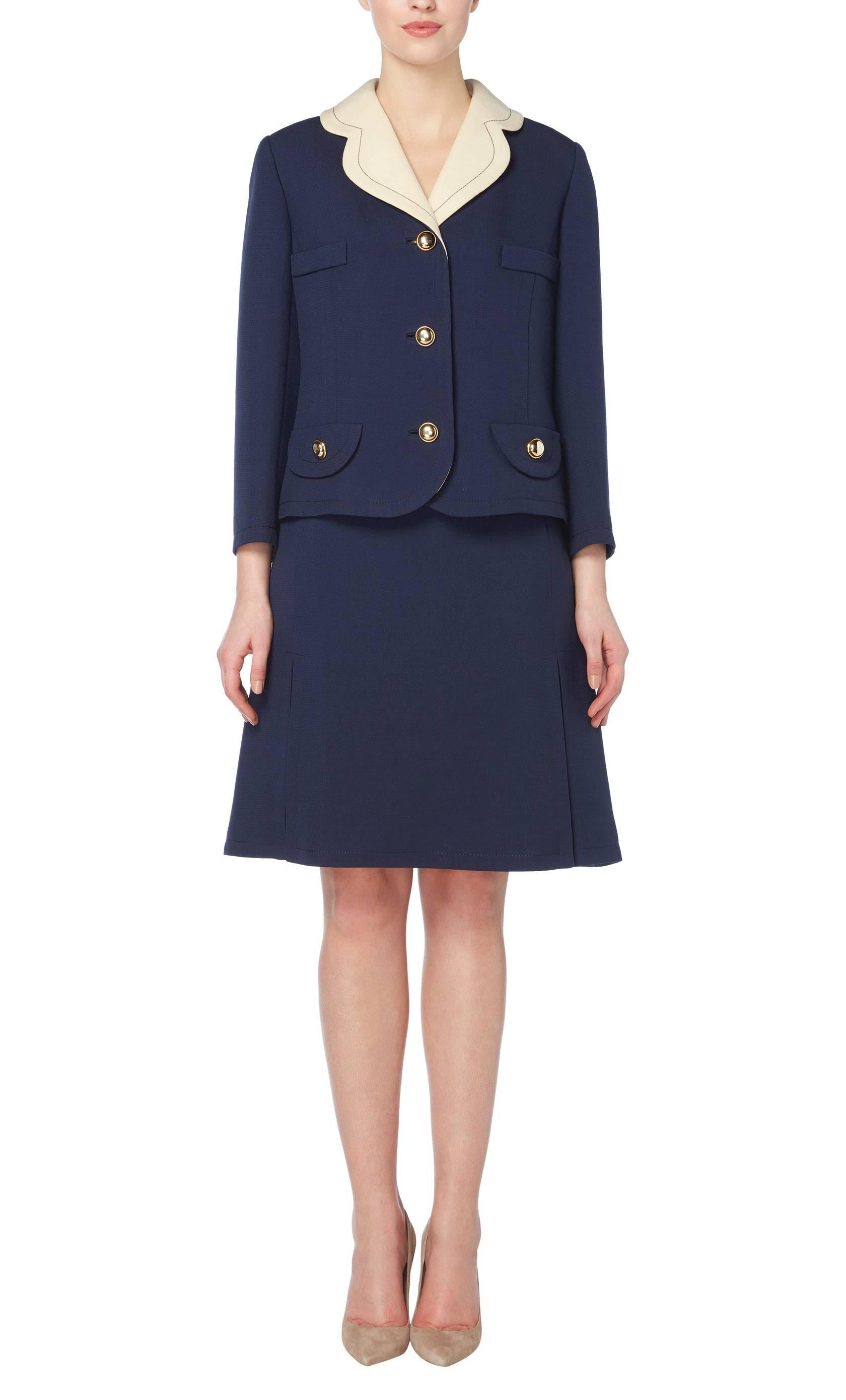 Perfect for the office or daytime events, this Jean Patou skirt suit has a nautical feel. Constructed in navy wool and featuring a contrasting ivory collar, the jacket fastens to the front and decorative pockets with gold metal buttons, while the