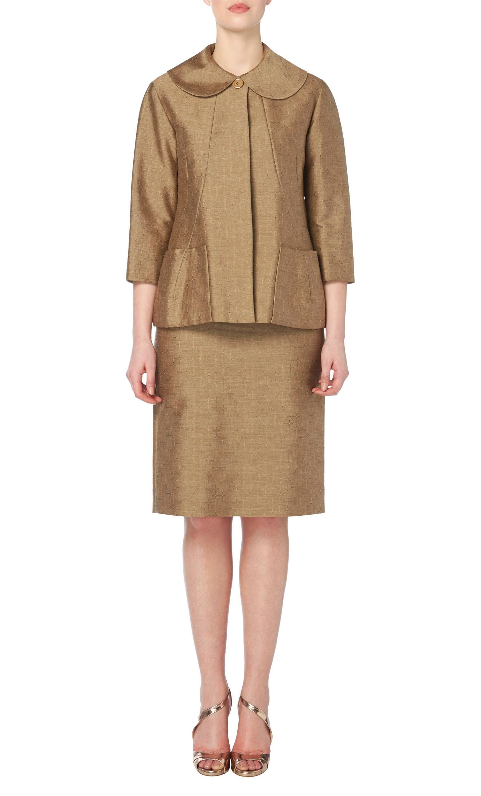 This haute couture suit by the master of 1960s modernism, Pierre Cardin, is hand-made in fine khaki wool. Formed of a box cut jacket with pockets and curving seam lines with a matching skirt, it's a perfect way to work timeless suiting into your