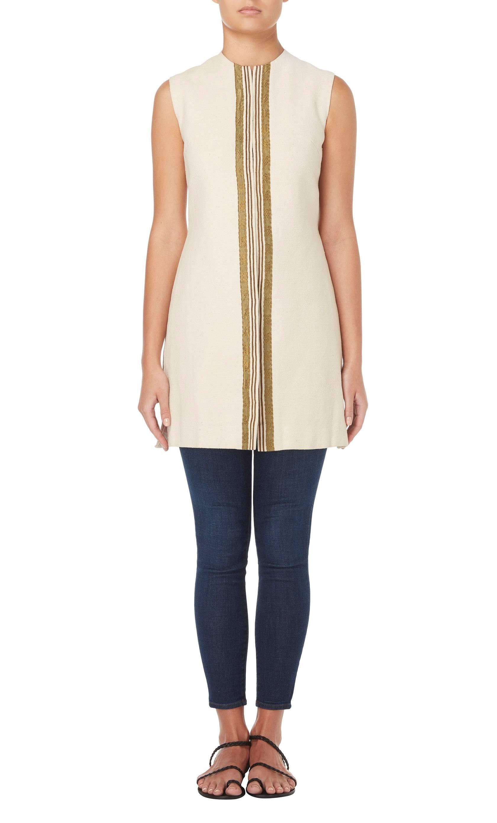 
Designed by the queen of bohemian chic, Thea Porter, and one of her rare couture pieces, this waistcoat is a fantastic piece. Constructed in ivory ribbed raw silk and trimmed with a gold braid to the leading edge, it is perfect for wearing over a