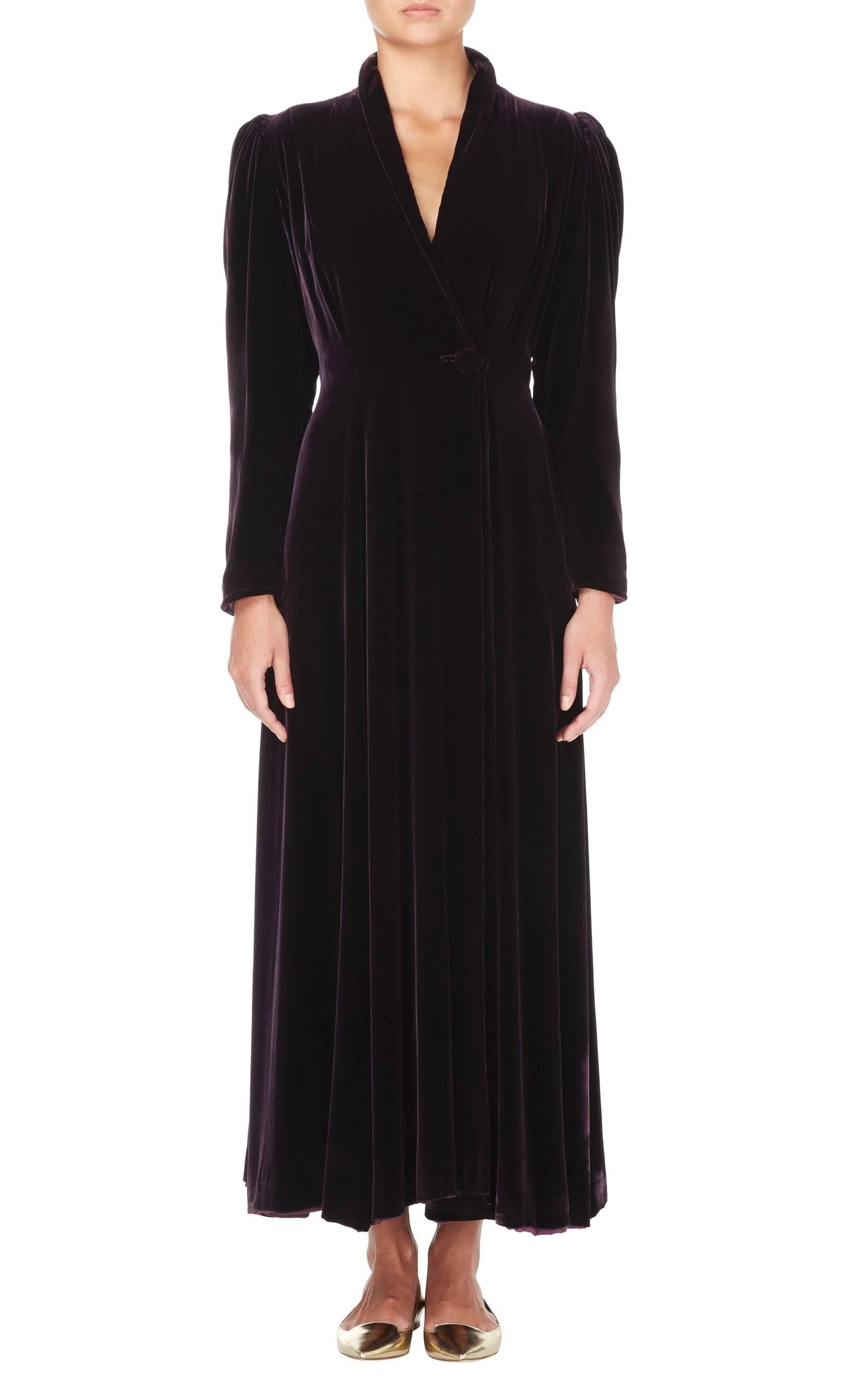 This opulent velvet evening coat by Valentina is a fabulous cover-up for an evening event. Constructed from plush velvet in a gorgeous shade of deep purple, the puffed shoulders give add a touch of drama to the otherwise linear silhouette. The