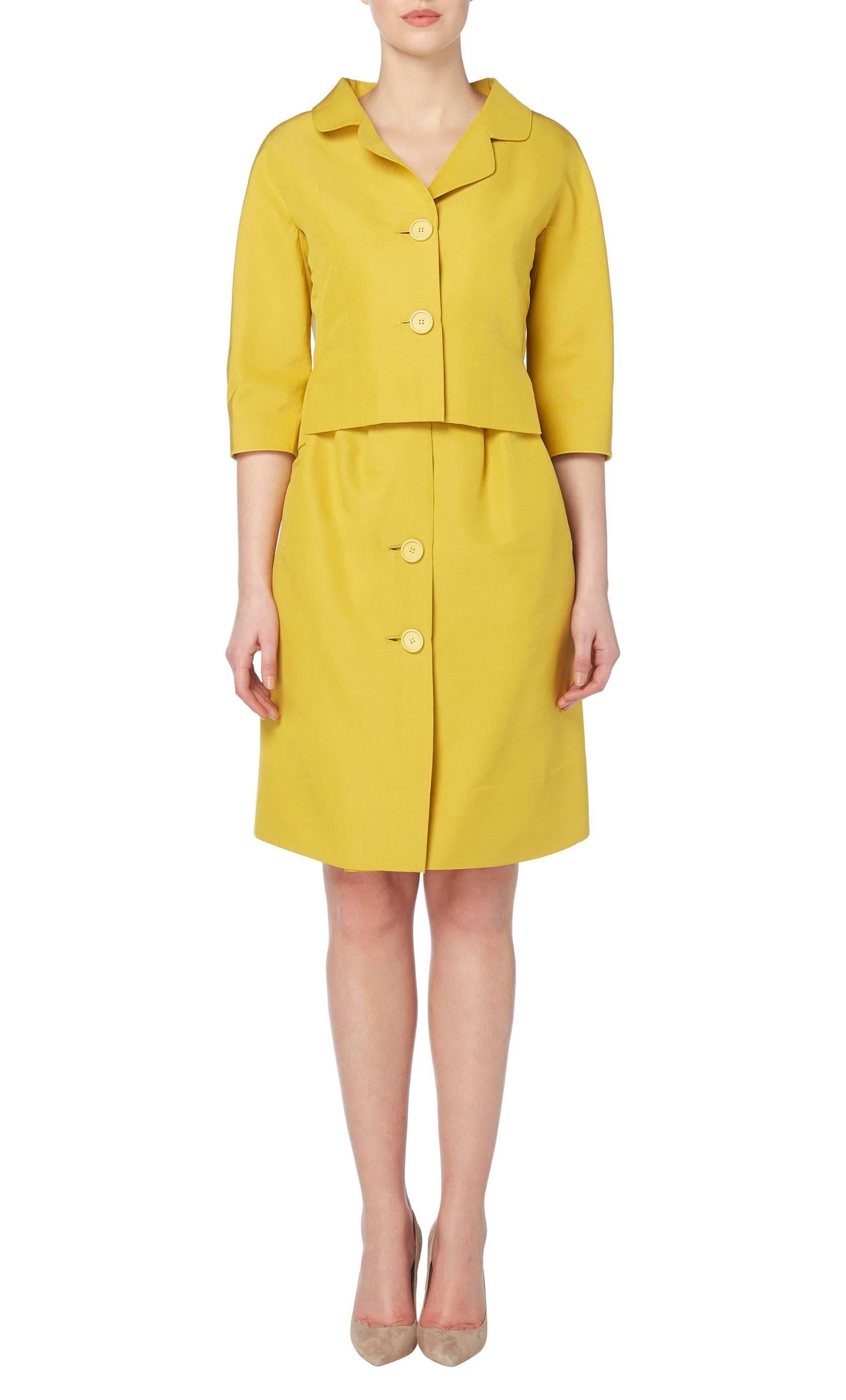 Constructed in vivid yellow silk, this superb haute couture suit exemplifies Balenciaga's obsession with tailoring and his legendary approach to pattern, cut and fit. The jacket features a double lapel collar and two buttons fastening to the front,