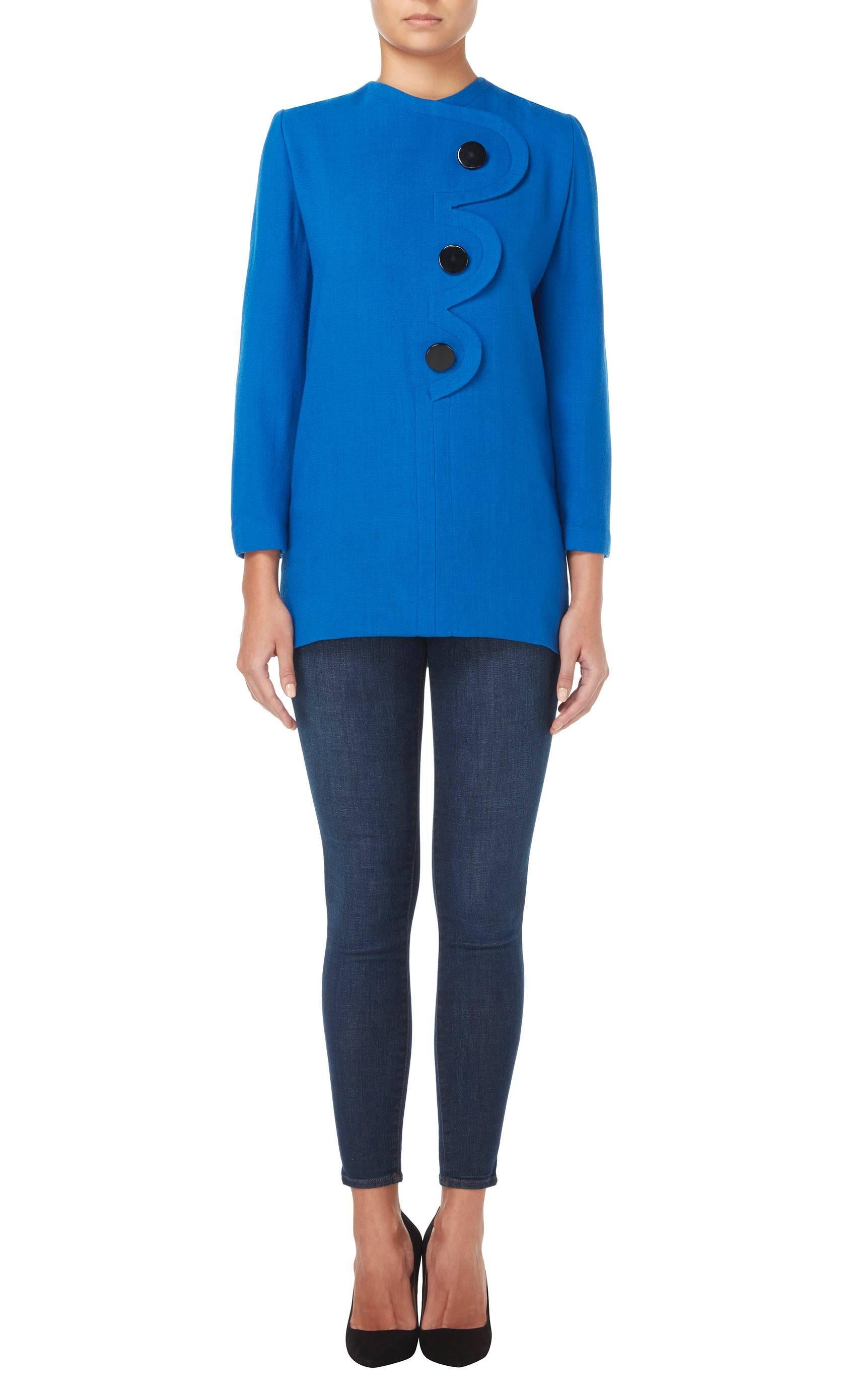 Constructed in bright blue wool crepe, this Pierre Cardin tunic top will add a pop of colour to a daytime look. With a scalloped detail and three decorative buttons to the front, this top is has a fun pop art aesthetic.

Constructed in blue wool