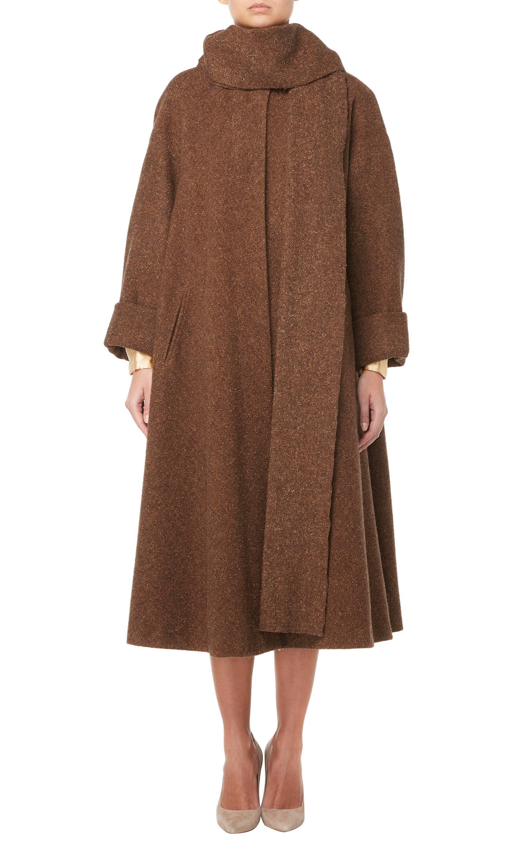 Comprising of a brown wool coat, matching skirt and gold silk shirt, this fabulous Guy Laroche haute couture three-piece is amazingly versatile. The shirt features pin tuck detailing and has a loose cut for a blouson shape, while the skirt is fitted