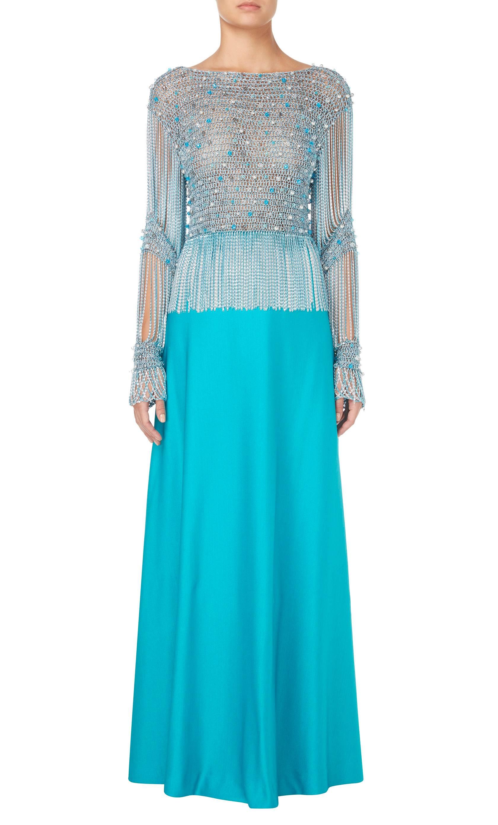 This incredible Azzaro ensemble, consisting of a metallic crop top and turquoise maxi skirt, is the ultimate in summer party dressing. The top is constructed in a metallic blue and silver knit and embellished with clear, blue and pearlescent beads,