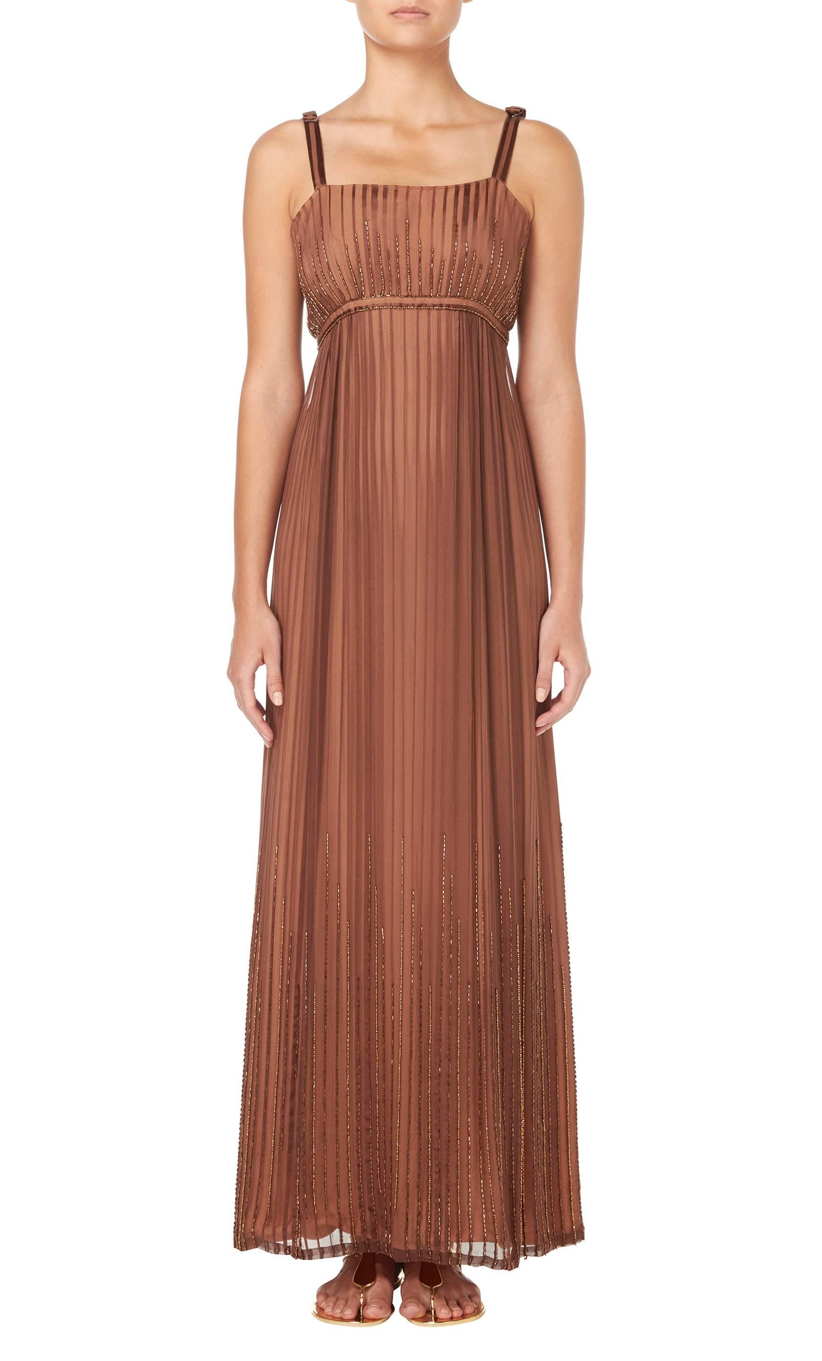 This beautiful summer dress by Alfred Bosand is constructed in striped brown silk chiffon with a tan lining. The dress is beaded over the bust and around the hemline and features a bow detail on the straps. Team with flat sandals and a raffia bag