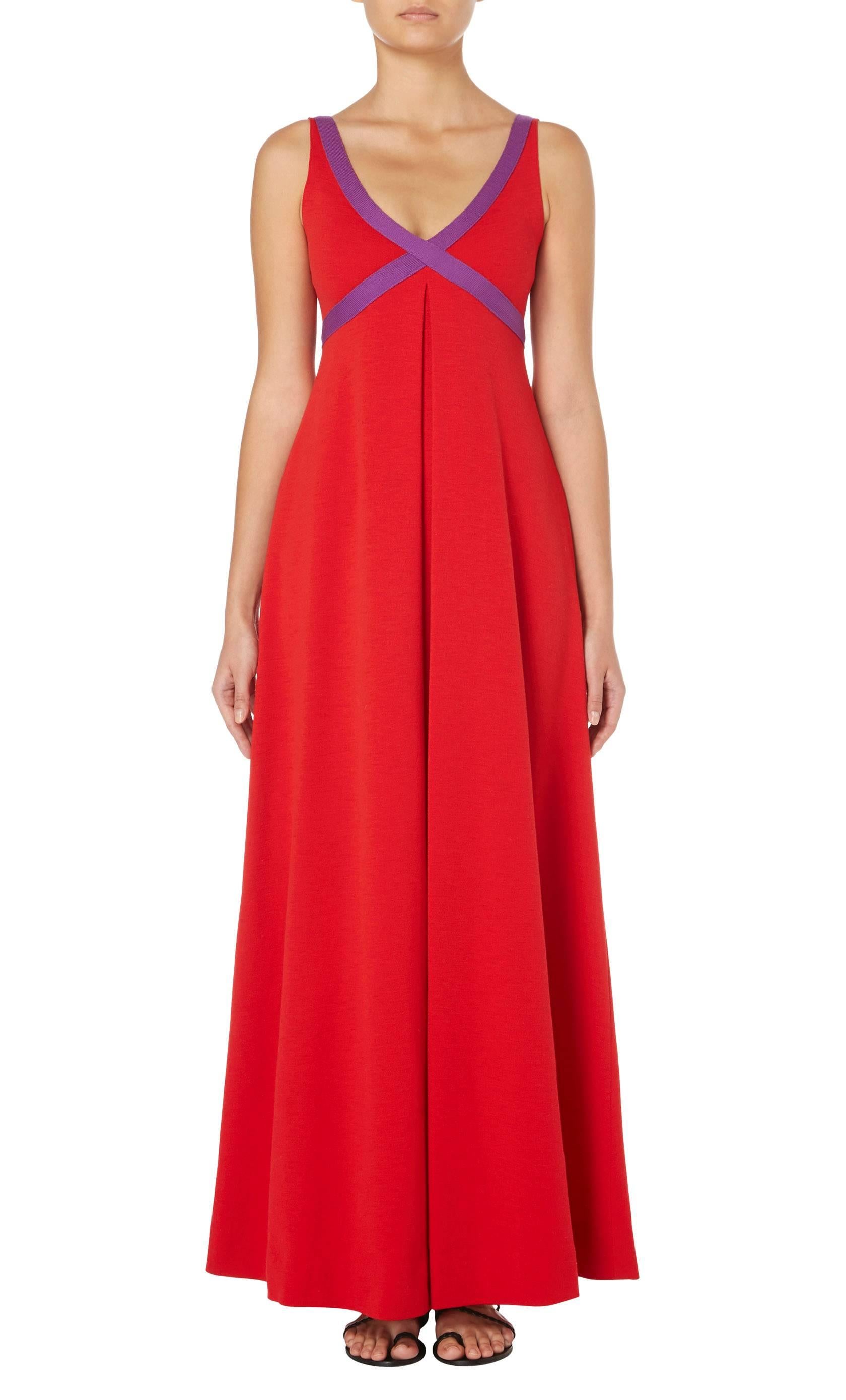 A fantastic example of Rudi Gernreich’s signature knitwear, this bold maxi dress is constructed in bright red wool and features a purple trim to the straps, crossing over the bust. Wide inverted pleats at the front and back create a pronounced