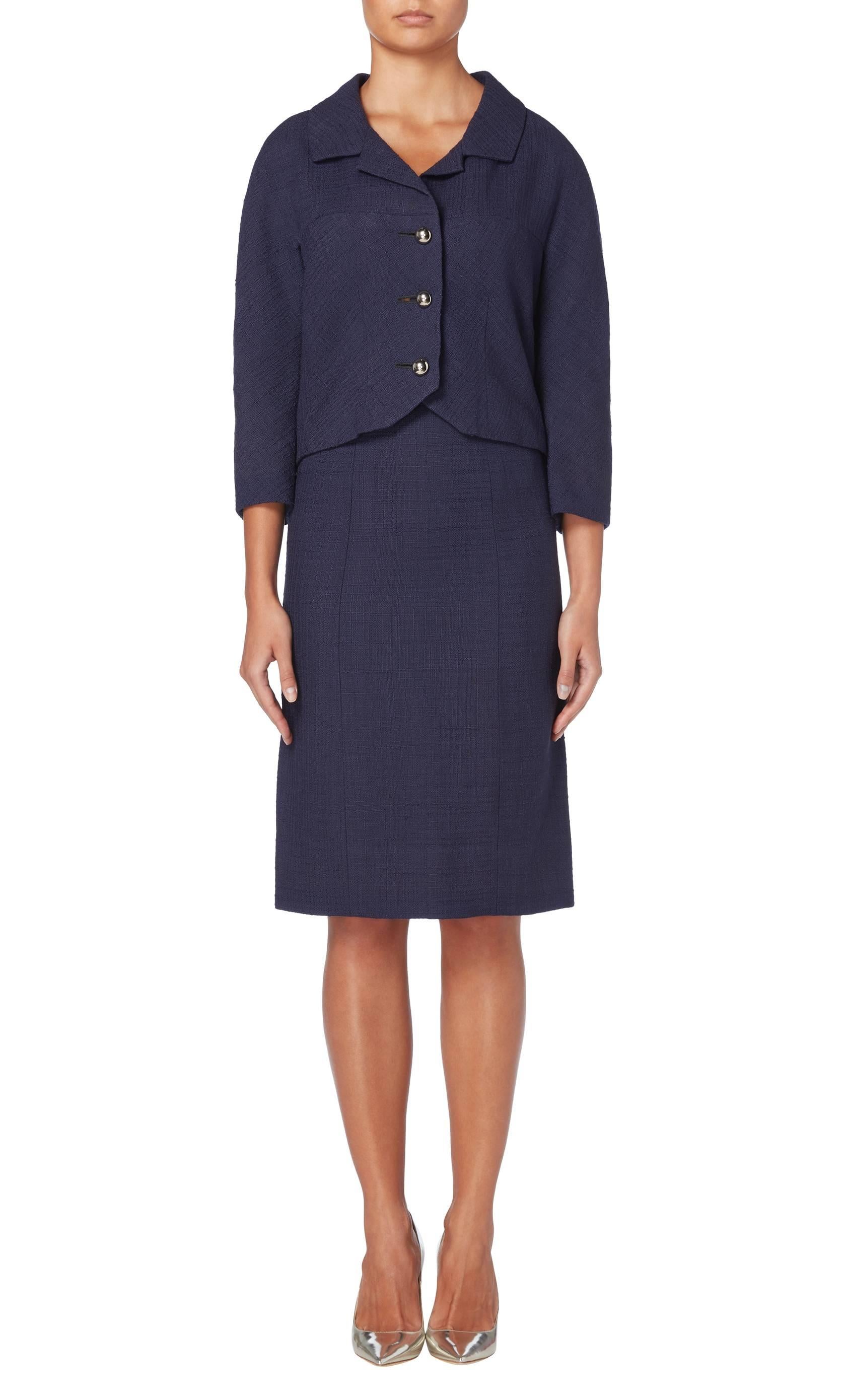 A great wardrobe staple, this Balenciaga haute couture skirt suit is a fantastic investment piece. Constructed in navy wool, the jacket features a double lapel collar and three-quarter length sleeves, while silver domed buttons fasten to the front.