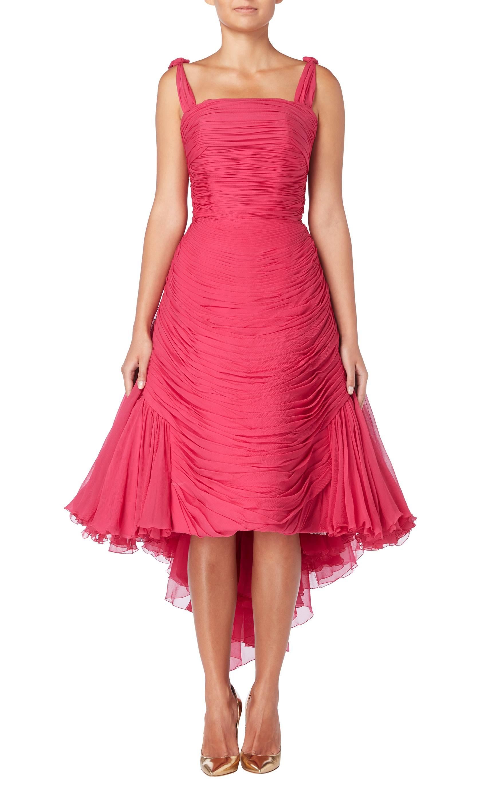A simply stunning piece of haute couture, this Jean Dessès cocktail dress is truly timeless. Constructed in a vivid shade of fuchsia pink chiffon, the front of the dress is horizontally pleated from the bust to the hem, while an internal boned