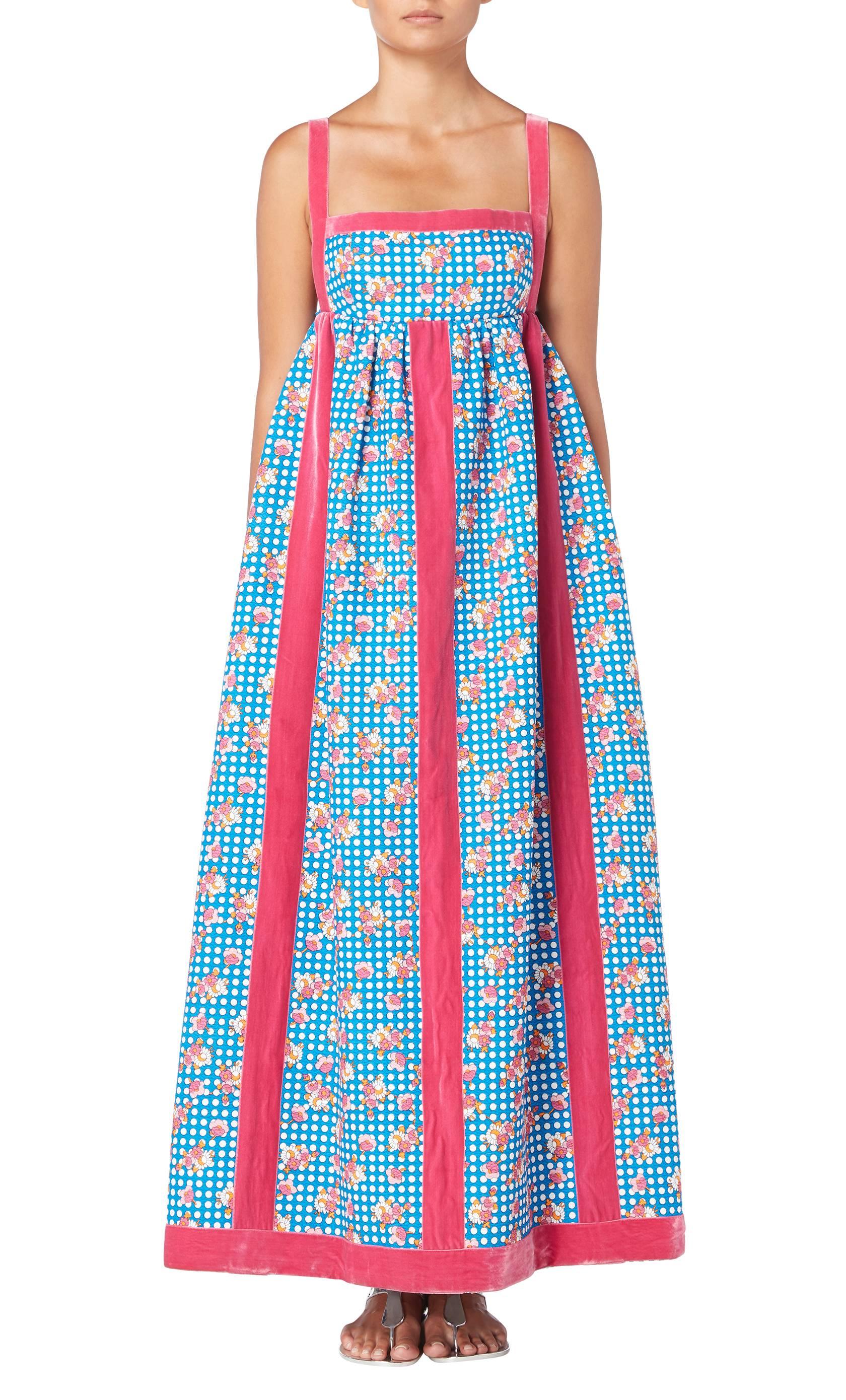 A great way of incorporating colour into a summer wardrobe, this Oscar de la Renta maxi dress is playful and fun! Constructed in bright blue textured cotton with a white polka dot and pink floral print, the dress features pink velvet stripes down