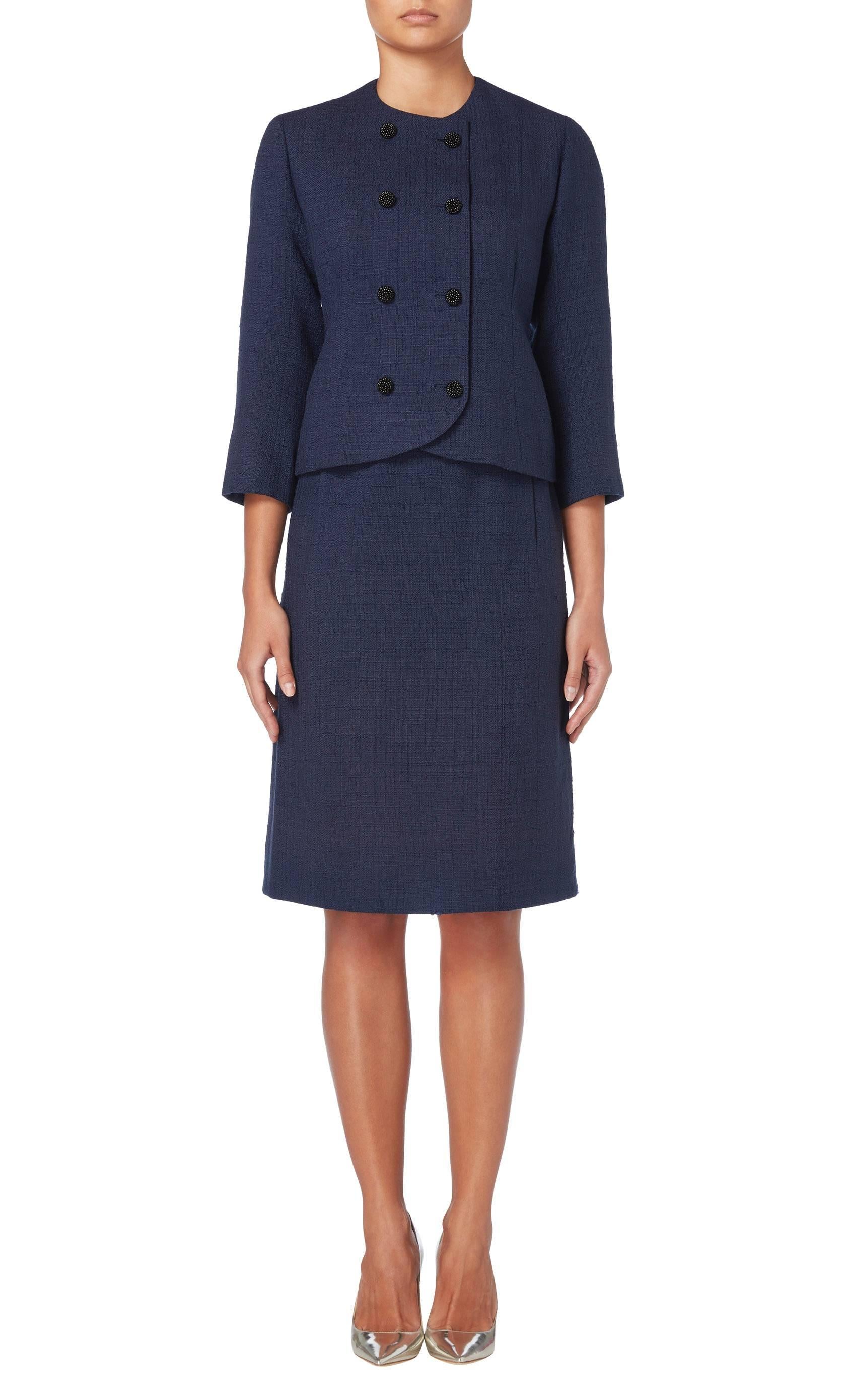 Introduce haute couture into a work wear wardrobe with this chic Balenciaga skirt suit. Constructed in navy wool, the double-breasted jacket fastens to the front with black beaded buttons and features a round neckline and three-quarter length