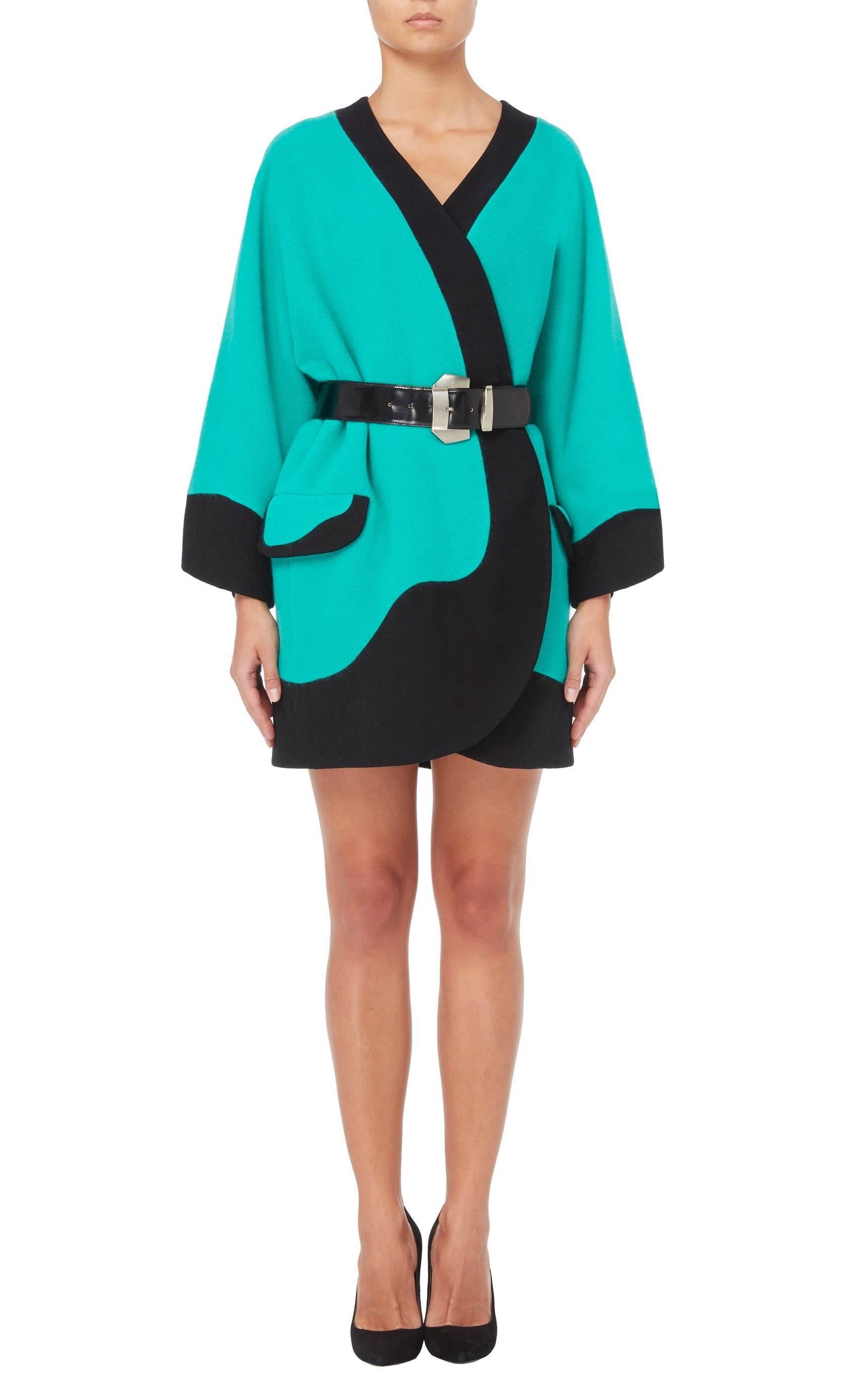 As seen on the Gianni Versace runway, the identical coat was modelled by Cindy Crawford. Constructed in turquoise wool, cashgora and angora mix, the coat features a contrasting black trim and decorative pockets on the hip, while the matching black