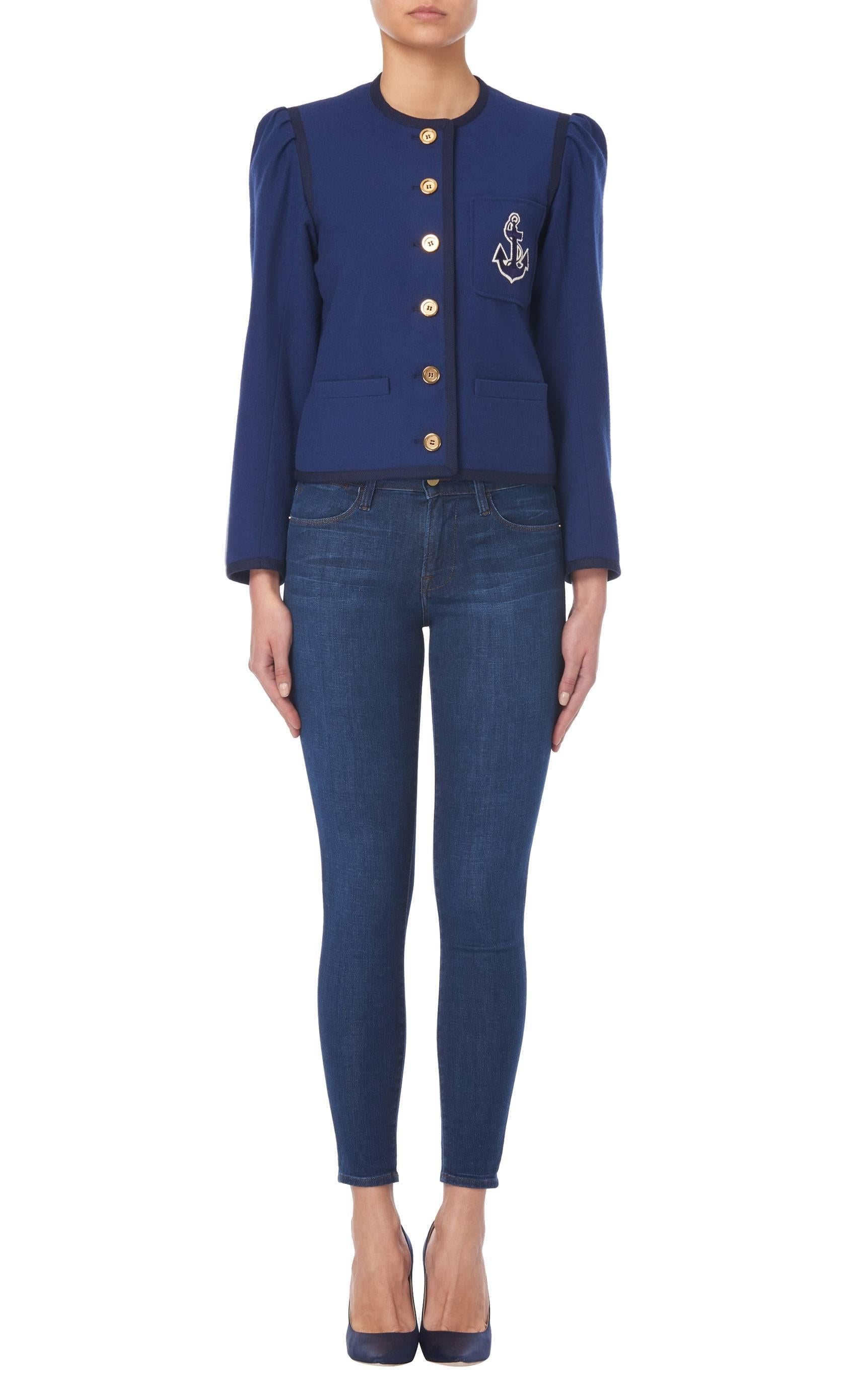 Constructed in navy wool, this Yves Saint Laurent jacket has a nautical feel with a navy and white anchor embroidered on the chest pocket. Featuring a round neckline and long sleeves, the jacket is edged with navy braided trim and fastens to the