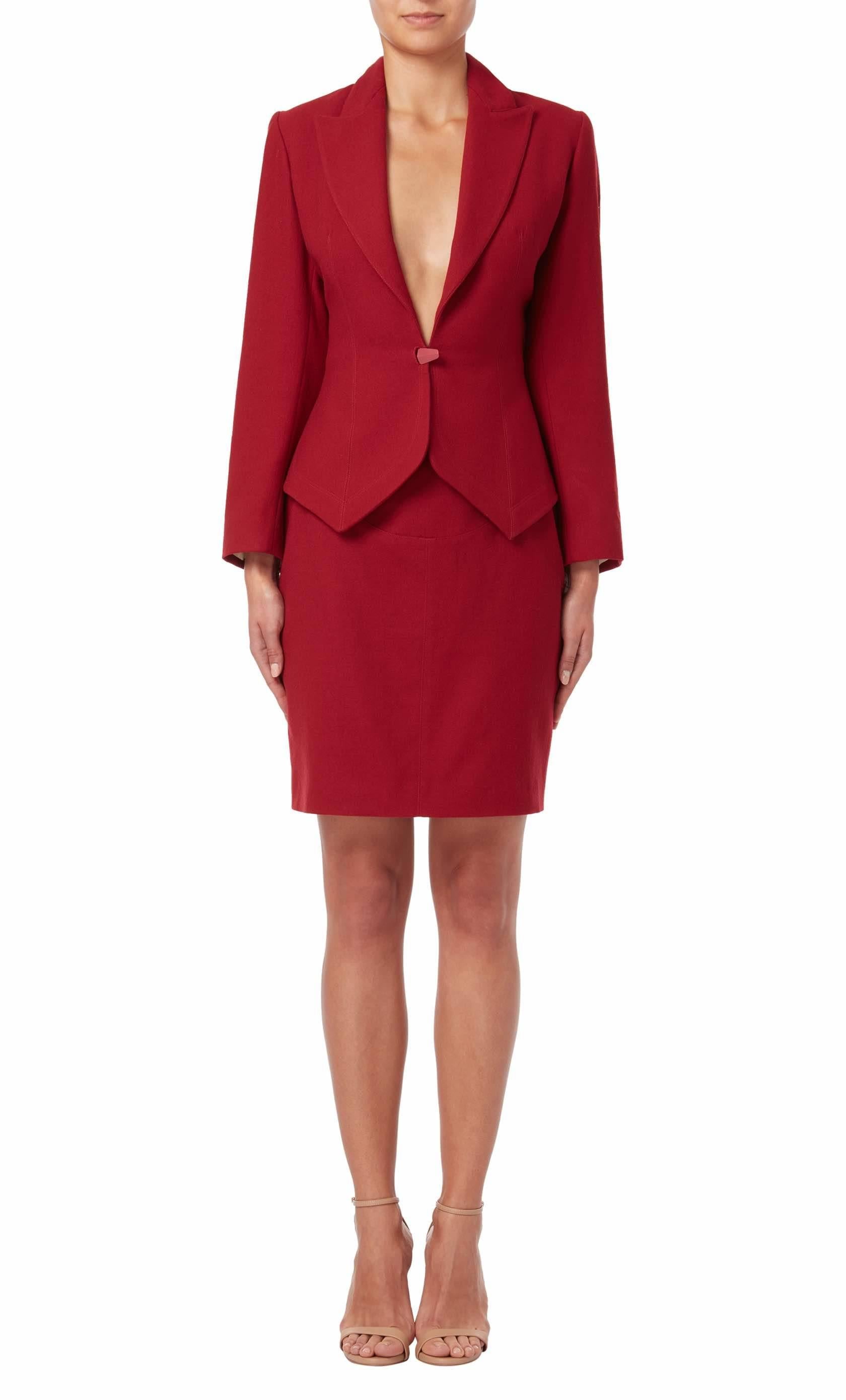 Red skirt suit by Azzedine Alaia from the Spring/Summer 1992 collection. The skirt suit features a form fitting silhouette and has a butterfly printed silk lining to the jacket.
 