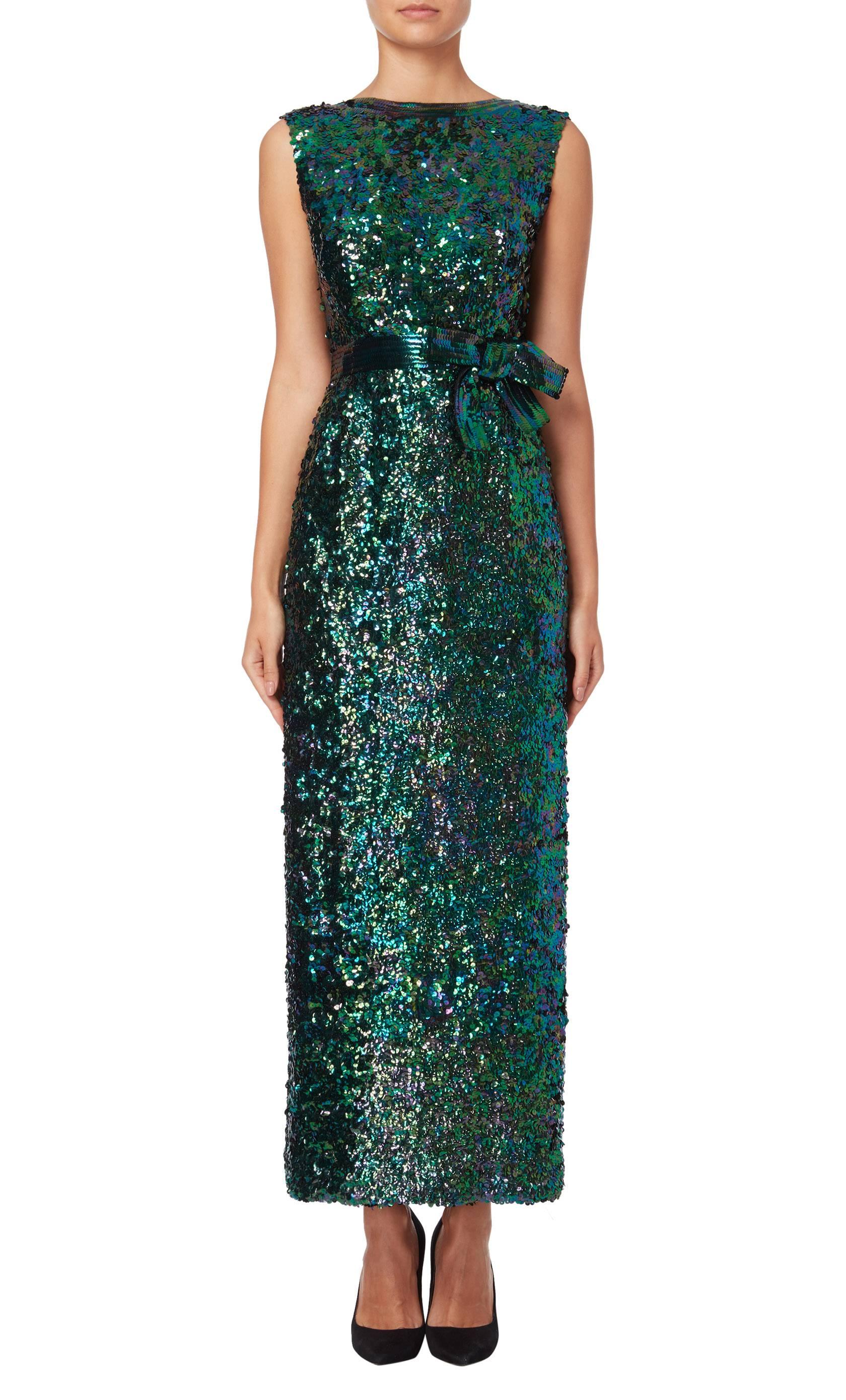 This elegant Norman Norell 1960’s gown is adorned with green, blue and purple sequins and features a sequined bow to the waist. A stunning low cut back is met with a short tie to the small of the back