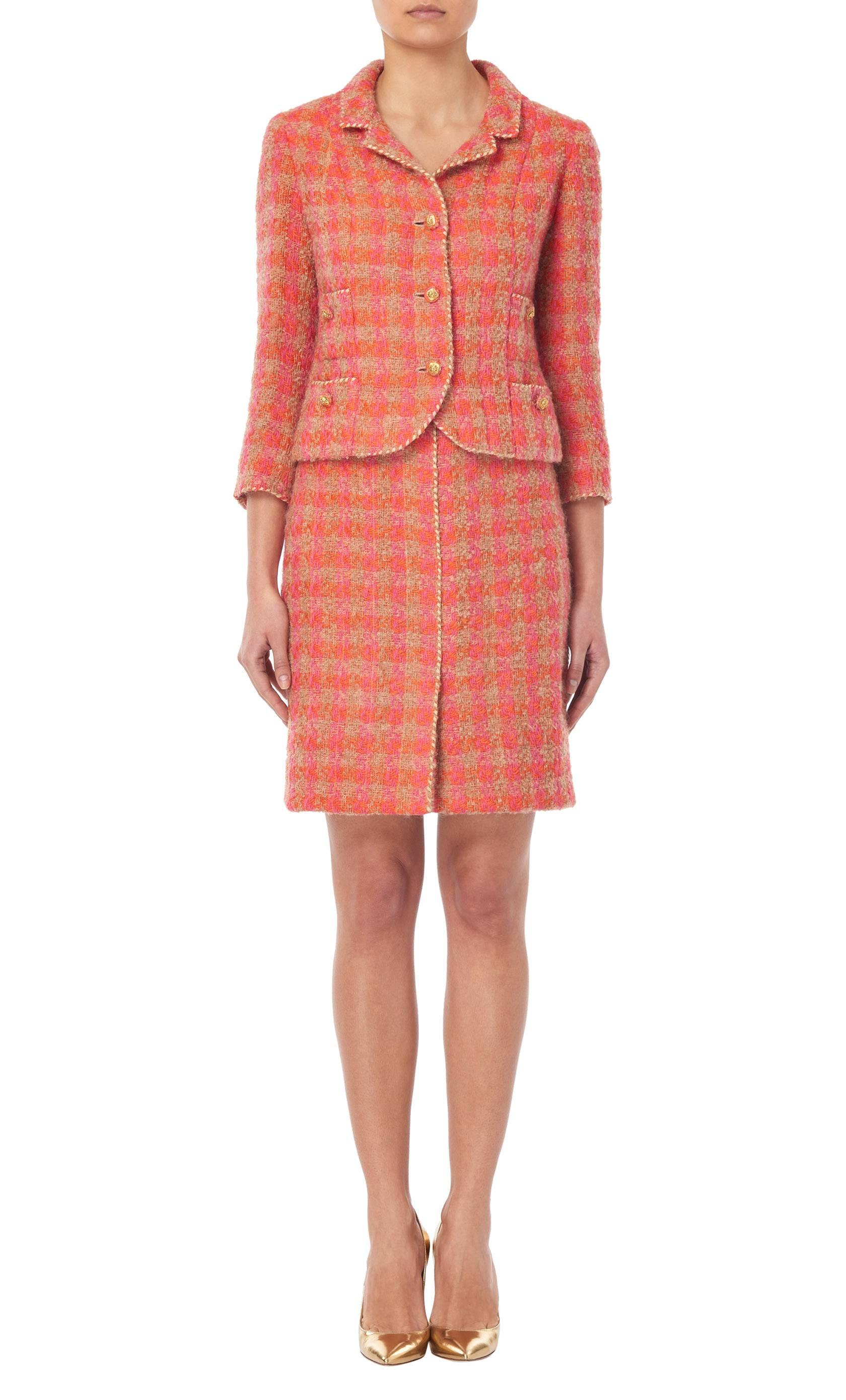 Constructed in bright pink, orange and beige checked bouclé wool this Marie Jansen suit comprises of a jacket and knee-length skirt. Featuring a double lapel collar, three-quarter length sleeves and pockets on the bust and hips, fabric-matched