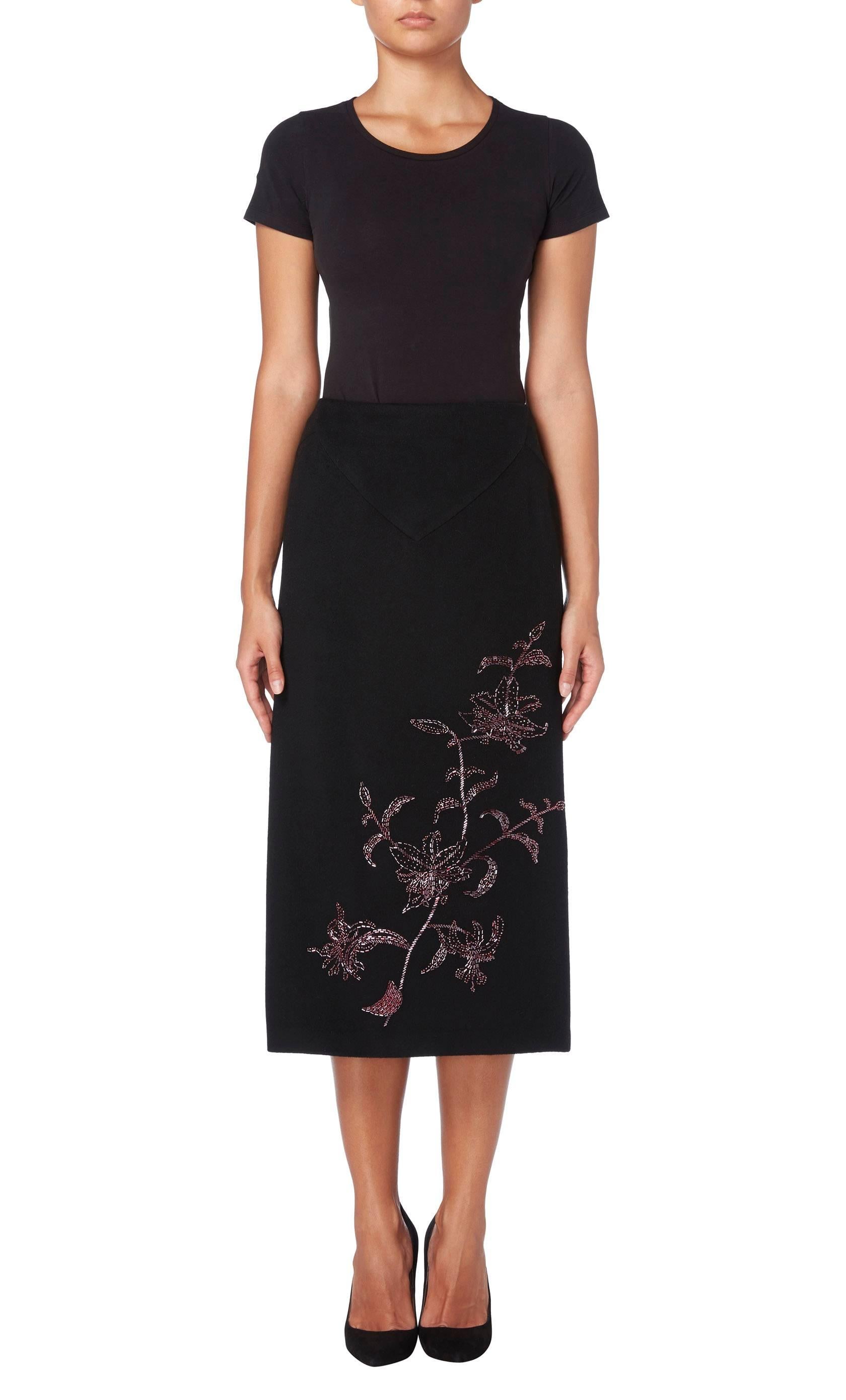 From Alexander McQueenAutumn/Winter 1988 collection, this pencil skirt is a versatile piece for work or everyday. Constructed in a black cashmere wool, the skirt has a luxurious feel and features a floral motif in purple bugle beads to the front and