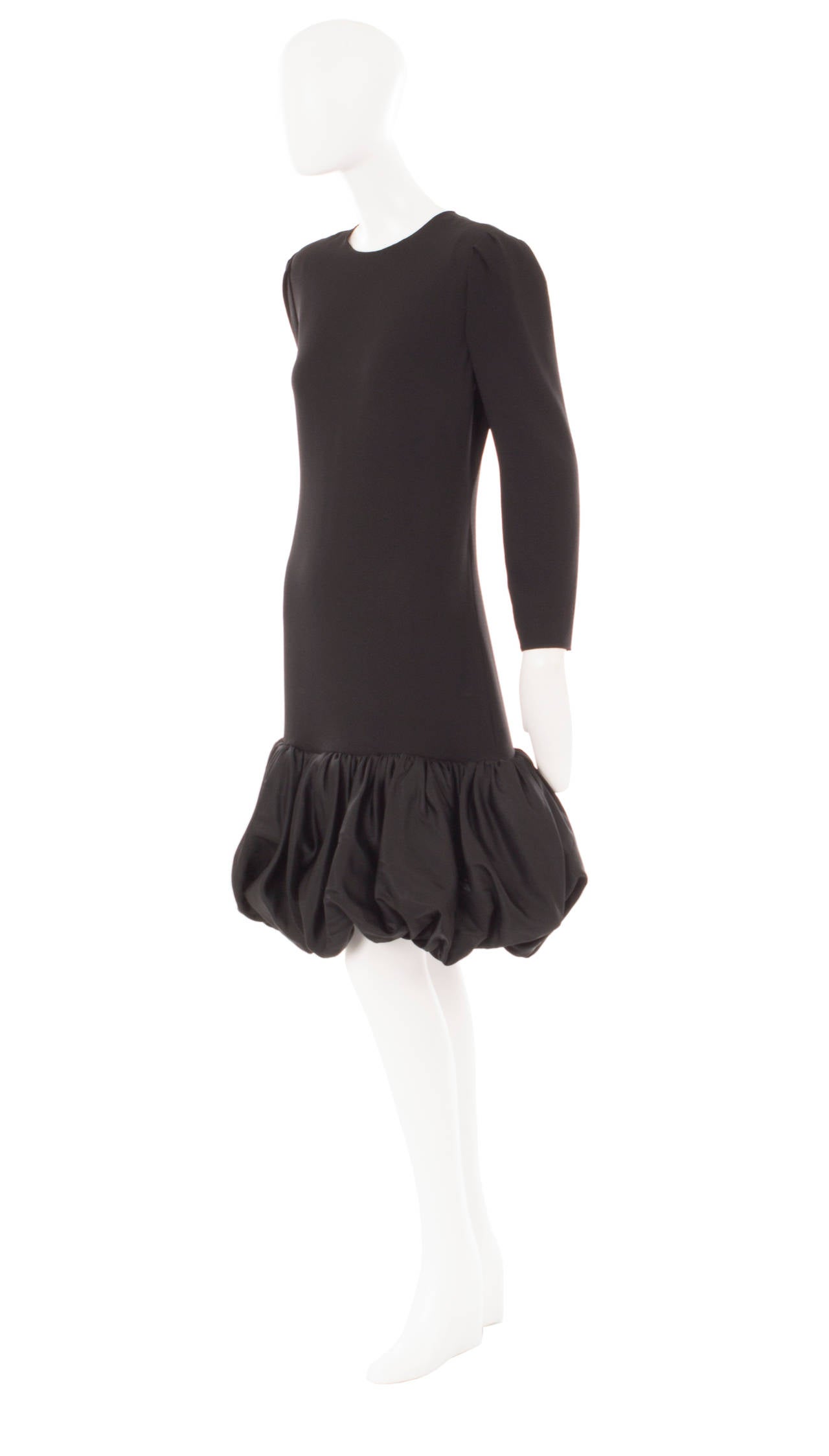 This Bill Blass black cocktail dress is perfect for parties! Constructed in wool crepe, the loose cut and long sleeves give a relaxed feel while the satin puffball hem adds drama.  Just add a pair of heels and a clutch bag to finish the look!

The