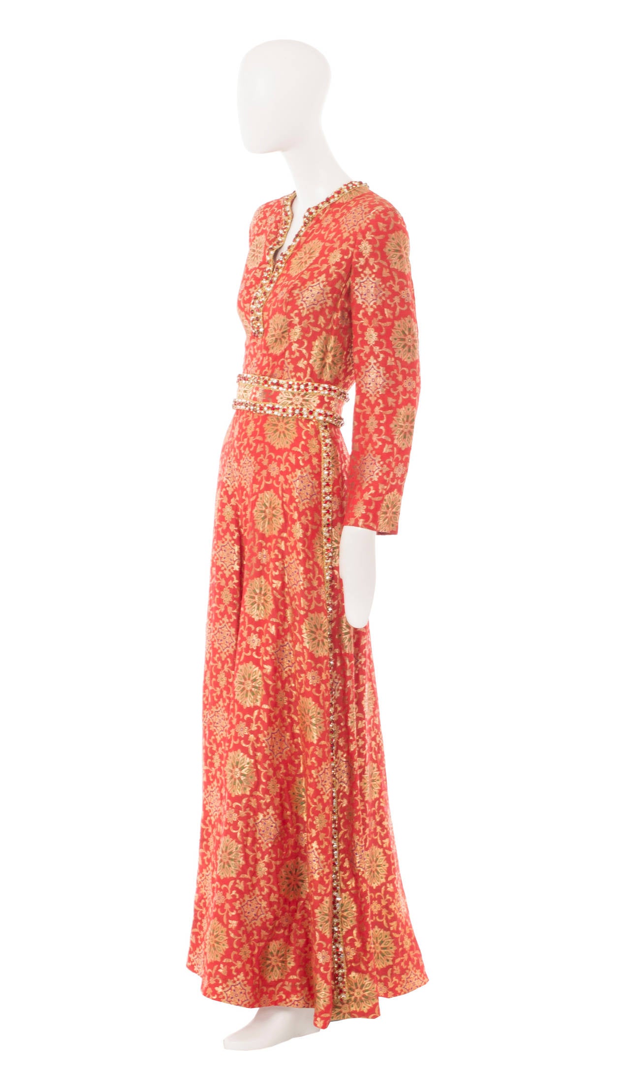 A fabulous alternative to a dress for a special event, this Adele Simpson jumpsuit, constructed in red silk featuring a gold brocade pattern, is ultra glamorous!  The jumpsuit features long sleeves, wide legs and hidden inside pockets on the hip.