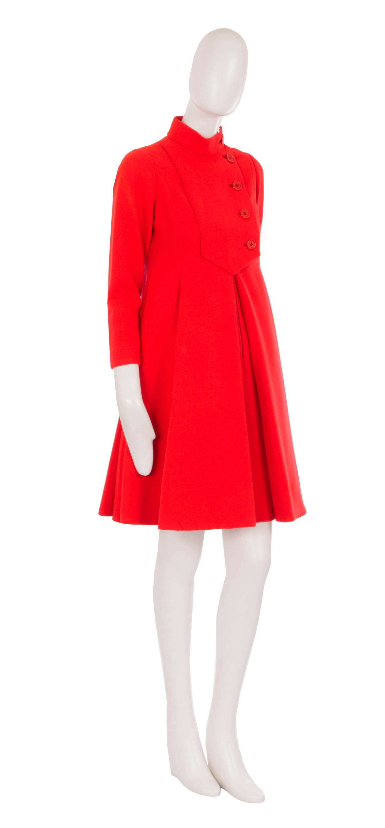 A fun daytime option, this Geoffrey Beene dress will add a pop of colour to any wardrobe. Constructed in vibrant red wool, the dress has a classic 60s A-line silhouette with box pleats in the skirt to increase volume. Fastening up the front with a