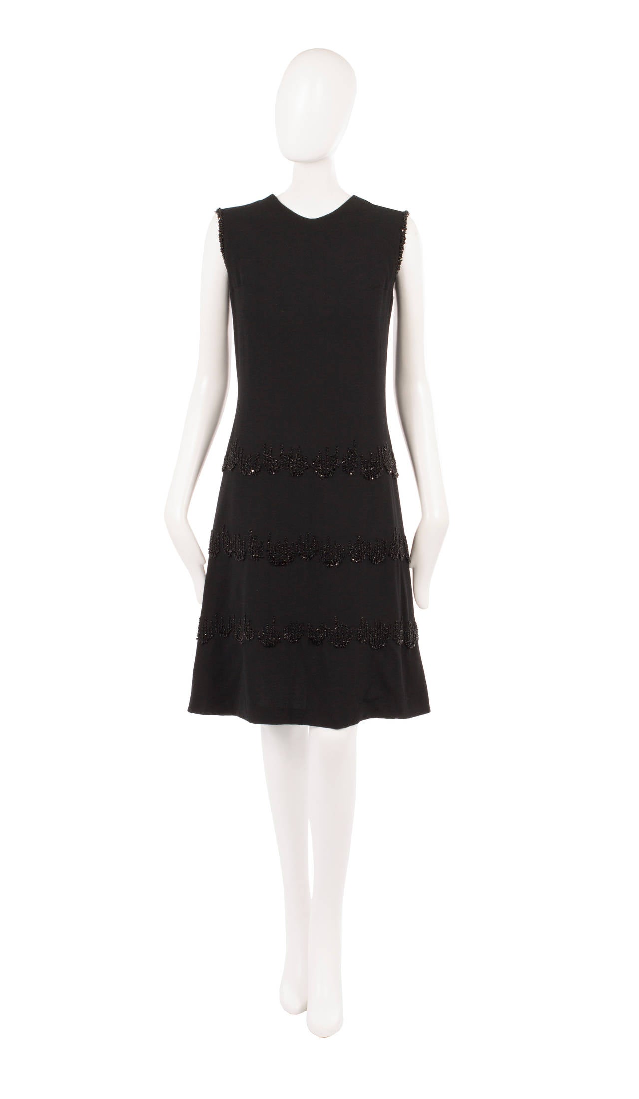An incredibly chic cocktail option, this haute couture Carven dress is constructed from black silk crepe and has a flattering 60s shift shape. Featuring bands of jet beading around the skirt and shoulders, the dress has a subtle sparkle and is