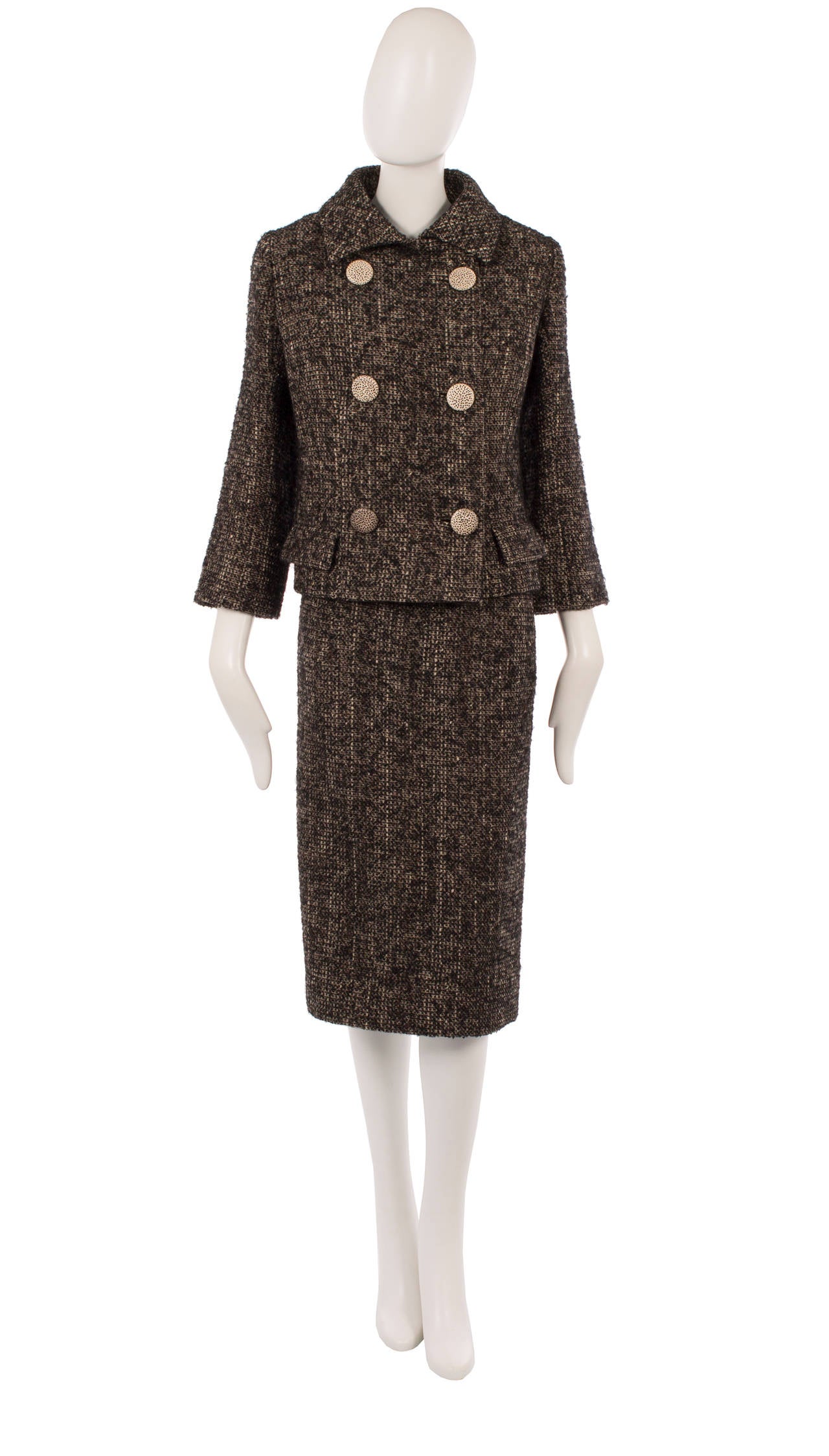 This Balenciaga haute couture skirt suit would make a great addition to any work wardrobe. Constructed in ivory, brown and black tweed, the boxy jacket is balanced by the slim cut of the skirt, creating a flattering silhouette, while the polka dot