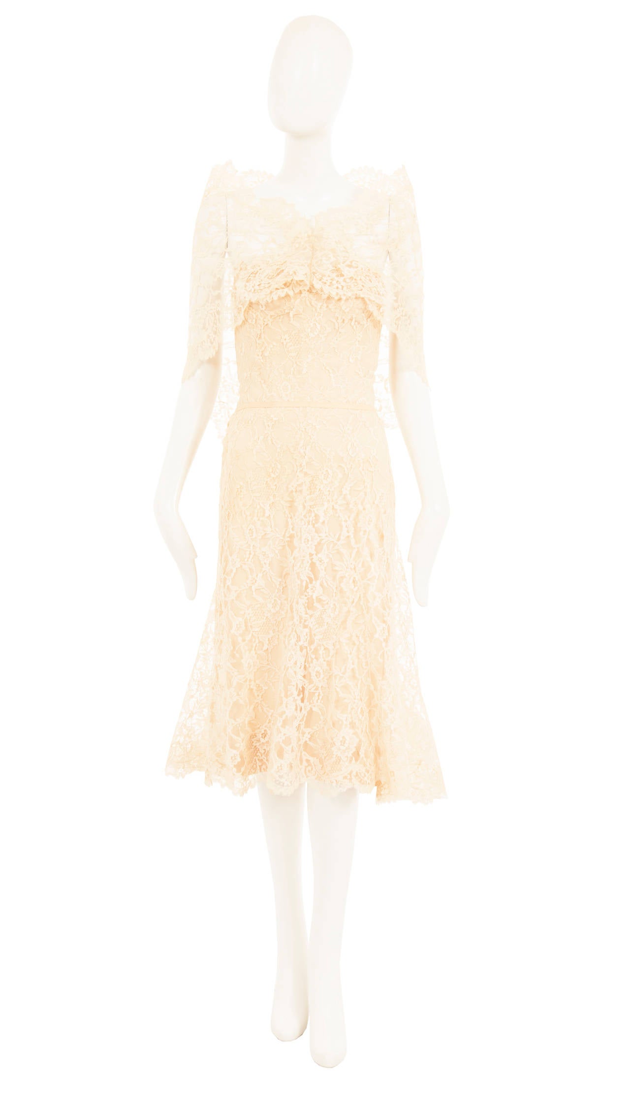 An exquisite piece of haute couture, this Chanel strapless cocktail dress is constructed of ivory Chantilly lace, fully lined in nude silk. The internal boned corset gives additional support, while a length of grosgrain ribbon runs around the
