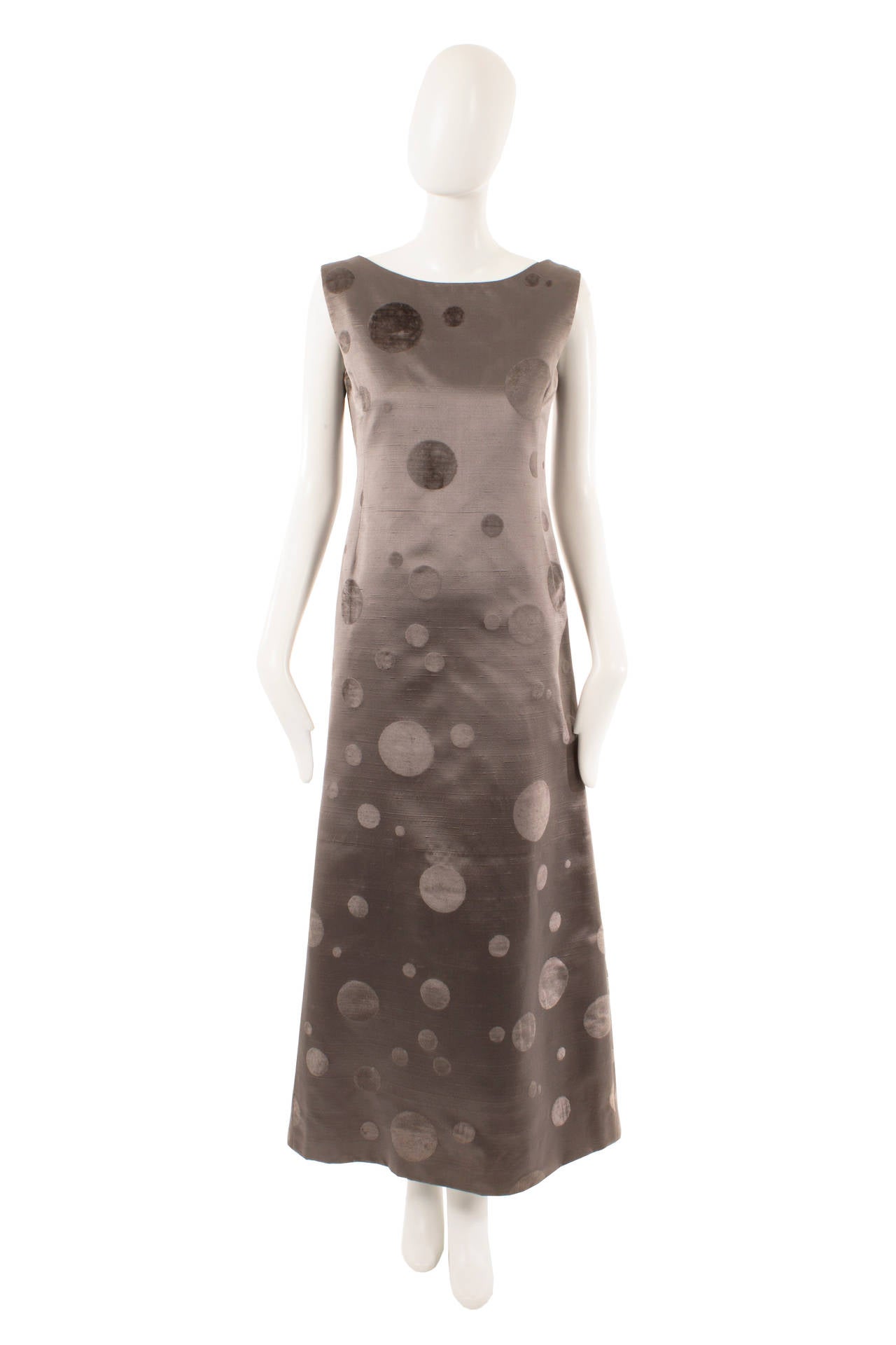 A fantastic statement piece, this Pierre Cardin full-length dress and matching capelet are perfect for black tie events. The pewter silk features flocked-effect polka dots in varying sizes, which give a subtle contrast in texture and colour while