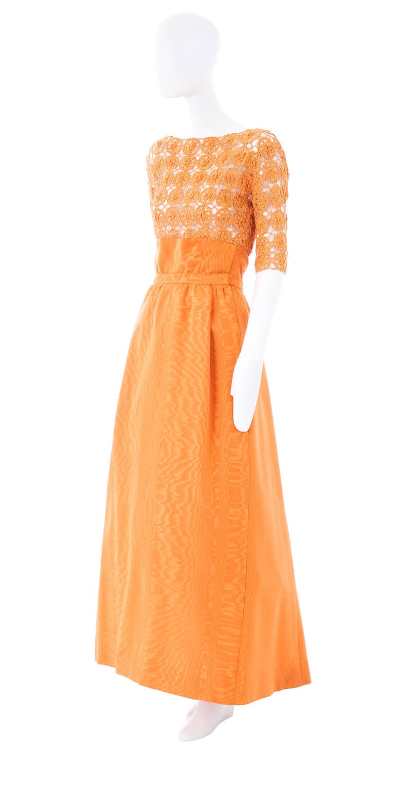 A vibrant orange Sybil Connolly ensemble, consisting of a wool crochet top and silk skirt, this beautiful two-piece will work for formal Events and Summer parties alike. The top features a boat neckline that scoops lower in the back, and