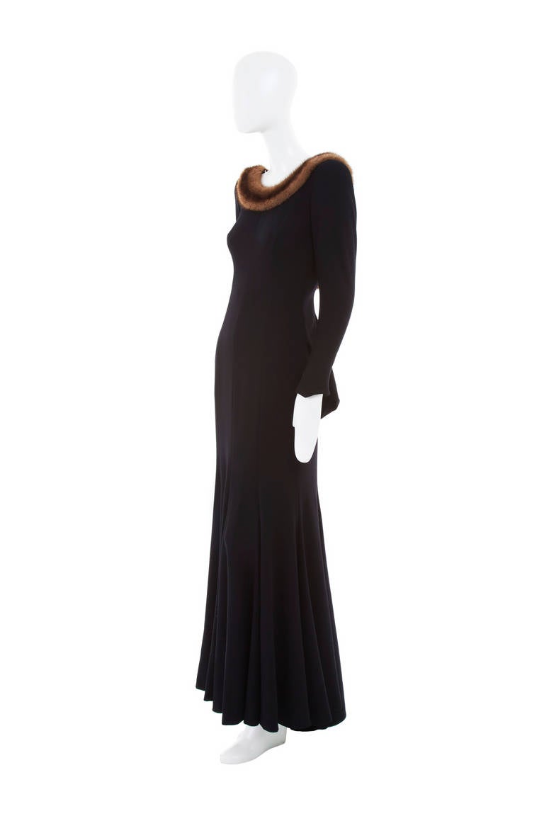 Inspired by a 1950s silhouette, this wonderful winter dress is extremely flattering and the perfect choice for a Black Tie event. Constructed in black wool crepe and detailing a mahogany ranch mink trim, flared skirt and tapered sleeves, the dress
