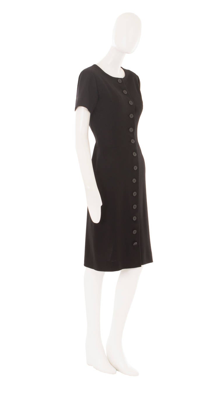 A beautiful piece of Balenciaga haute couture, this dress will be the perfect addition to a modern wardrobe. Whether worn for the office or out to a dinner this expertly cut piece, constructed in black wool, is an utterly chic choice. Featuring a