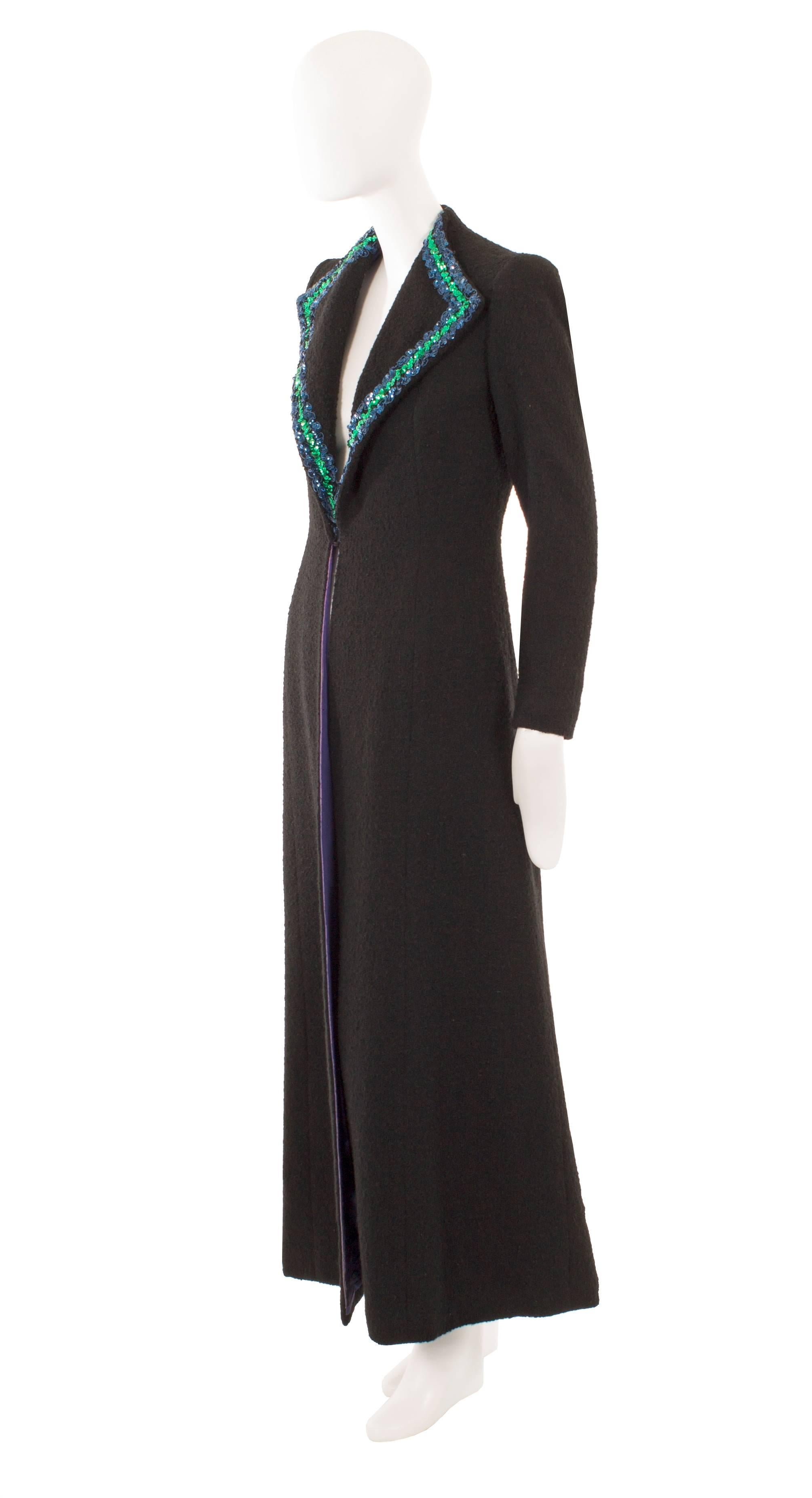 An incredibly rare piece of Schiaparelli haute couture, this coat is a fantastic piece of fashion history! Constructed from black Linton wool, the coat is sharply tailored with a double lapel collar embellished with blue and green sequins. A single