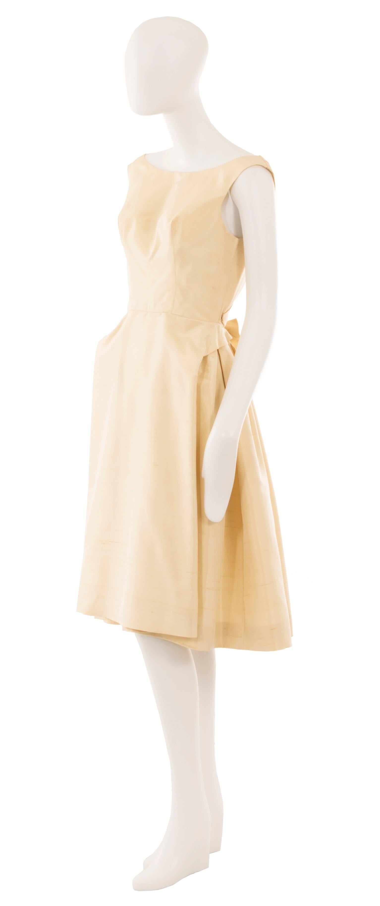 Semplice ma assolutamente chic, questo splendido abito è l'alternativa perfetta a un abito da sposa tradizionale o a un LBD. Realizzato in seta color avorio, l'abito ha un'elegante scollatura sul davanti e si abbassa sul retro per mostrare la