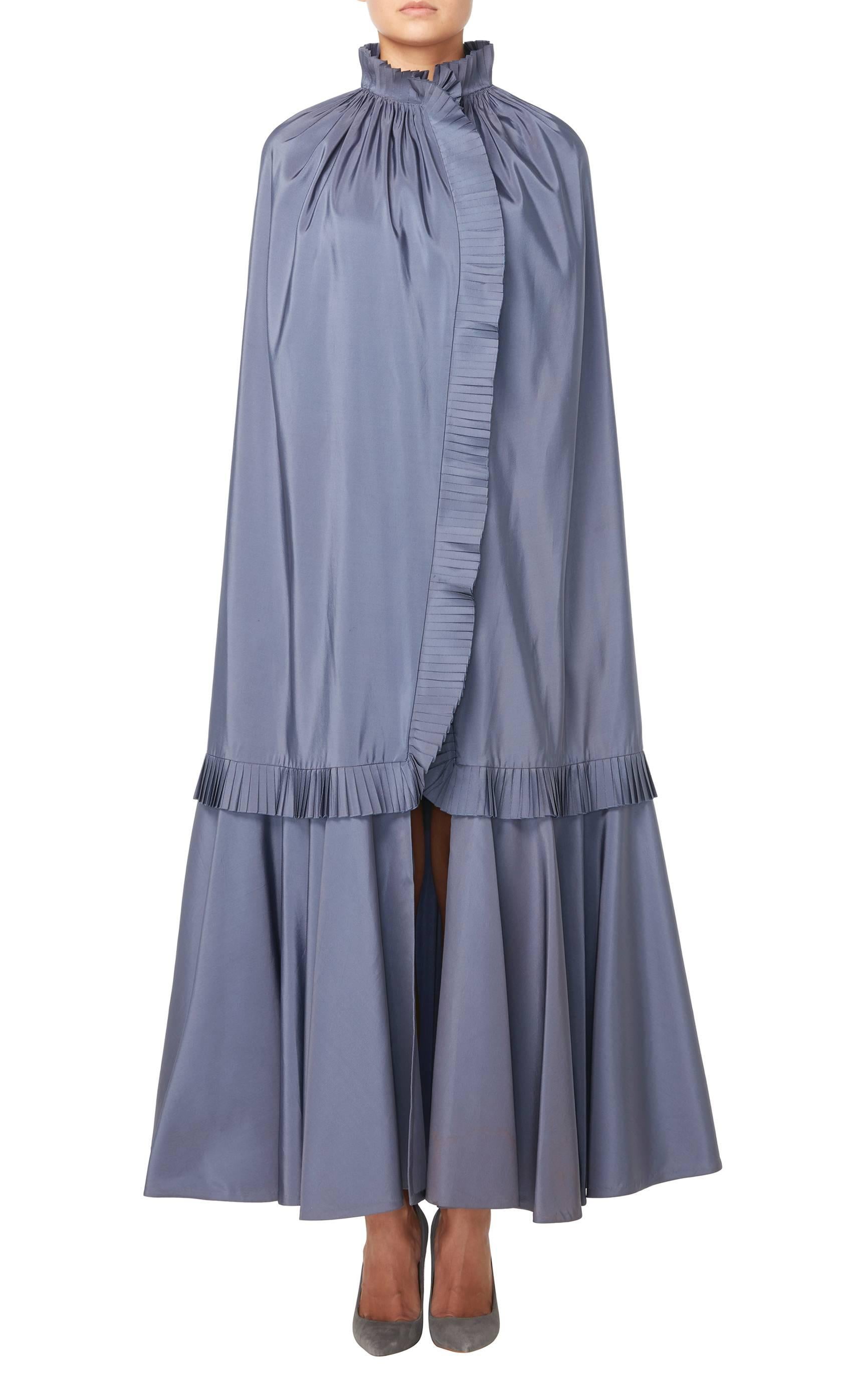 A stunning evening cape, constructed in ‘Lanvin blue’ silk faille, this piece will look fabulous worn over an evening gown or cocktail dress. The pleated collar, trim and hem add a touch of drama, while the single fastening on the neck allows the