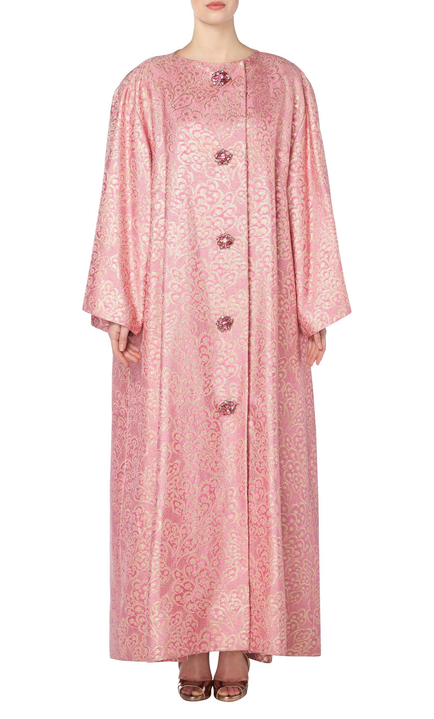This dramatic and opulent Nina Ricci haute couture evening coat is composed of a spectacular hot pink and gold lurex, with jewelled buttons and hot pink silk lining. Rare and perfect for making a real entrance!

Constructed in pink and gold