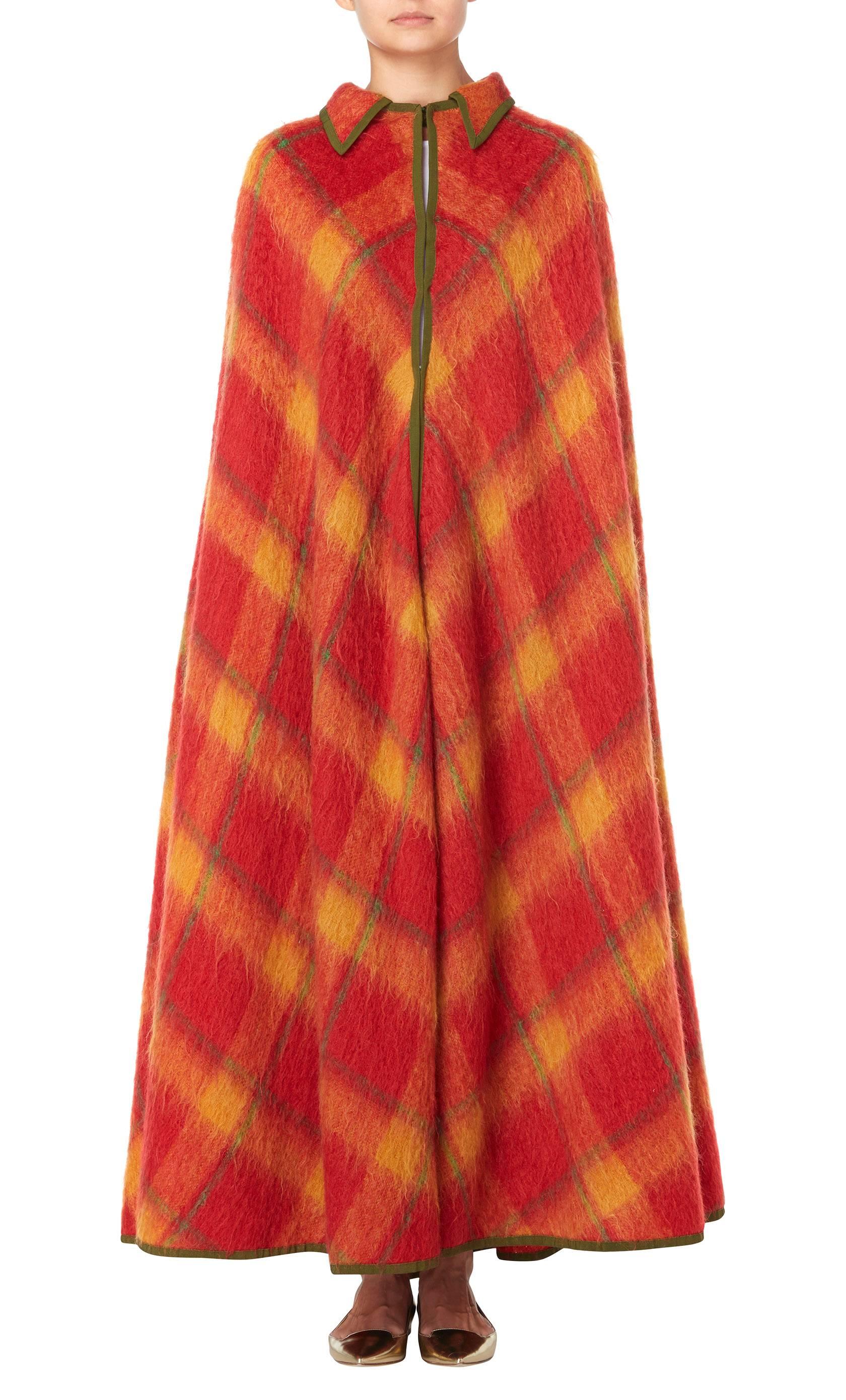 Perfect for cold days, this Lanvin haute couture cape will make a great addition to a Winter wardrobe. Constructed in tartan mohair in autumnal shades of orange, green and yellow, a green grosgrain ribbon trims the edges. Featuring a single lapel