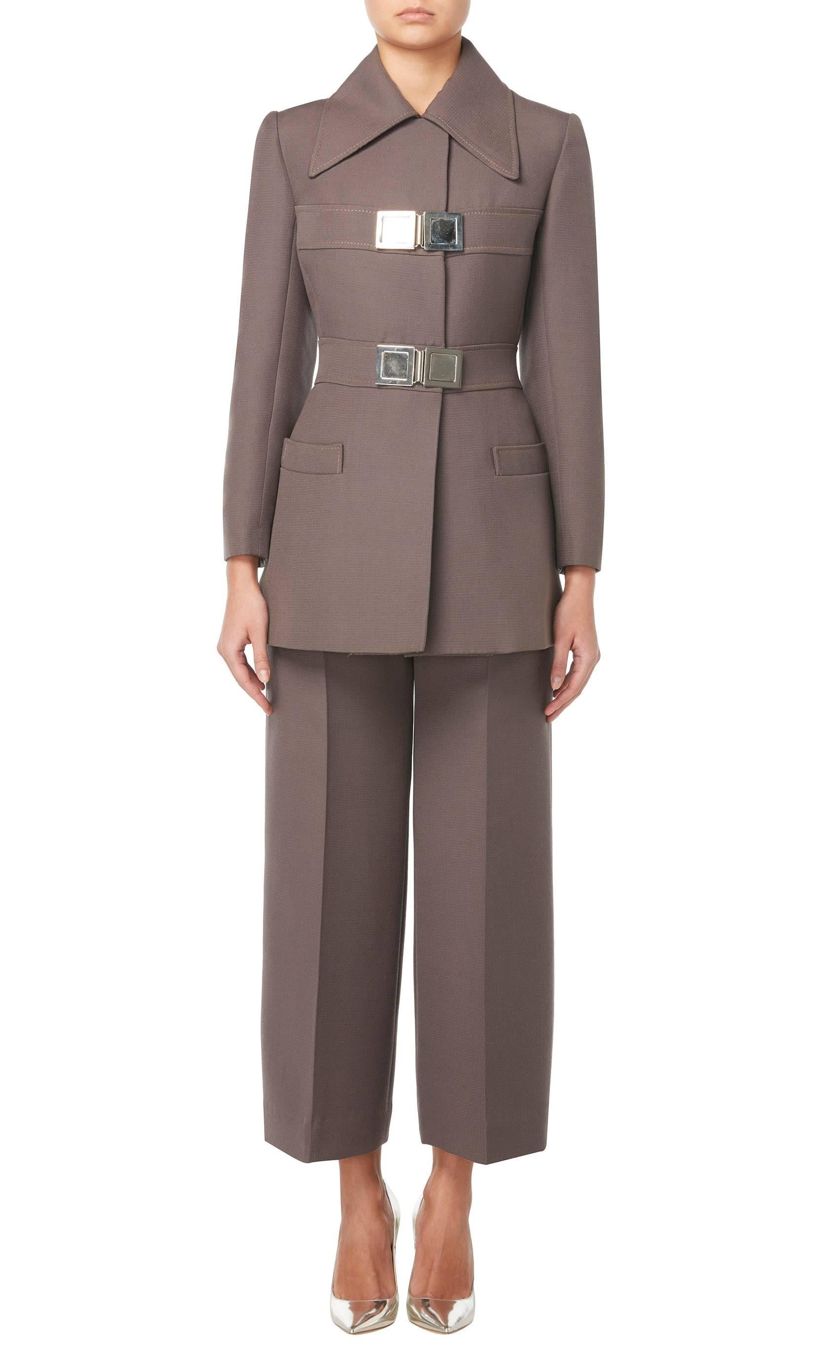 This sharply tailored, military-inspired trouser suit by Jean Patou will make a great alternative to traditional office wear. Constructed in brown wool, the suit is comprised of a jacket and straight cut trousers. With an exaggerated collar, the