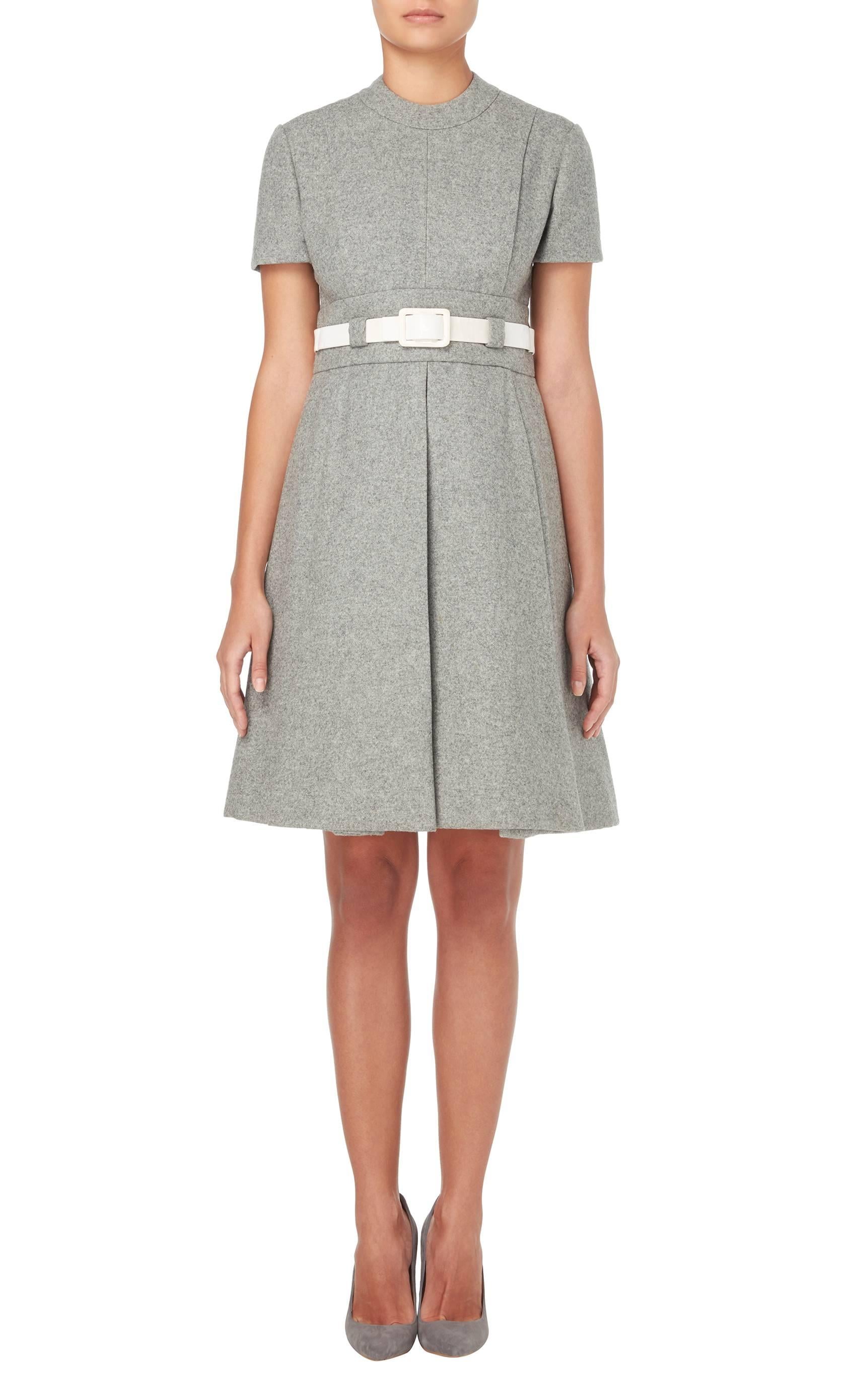 Constructed in grey wool-felt
Featuring a white vinyl belt and box pleated skirt
Zip fastening to rear
Excellent condition with the original label, lining and fastenings
Professionally dry cleaned and ozone-treated
Inspected by a couture-trained