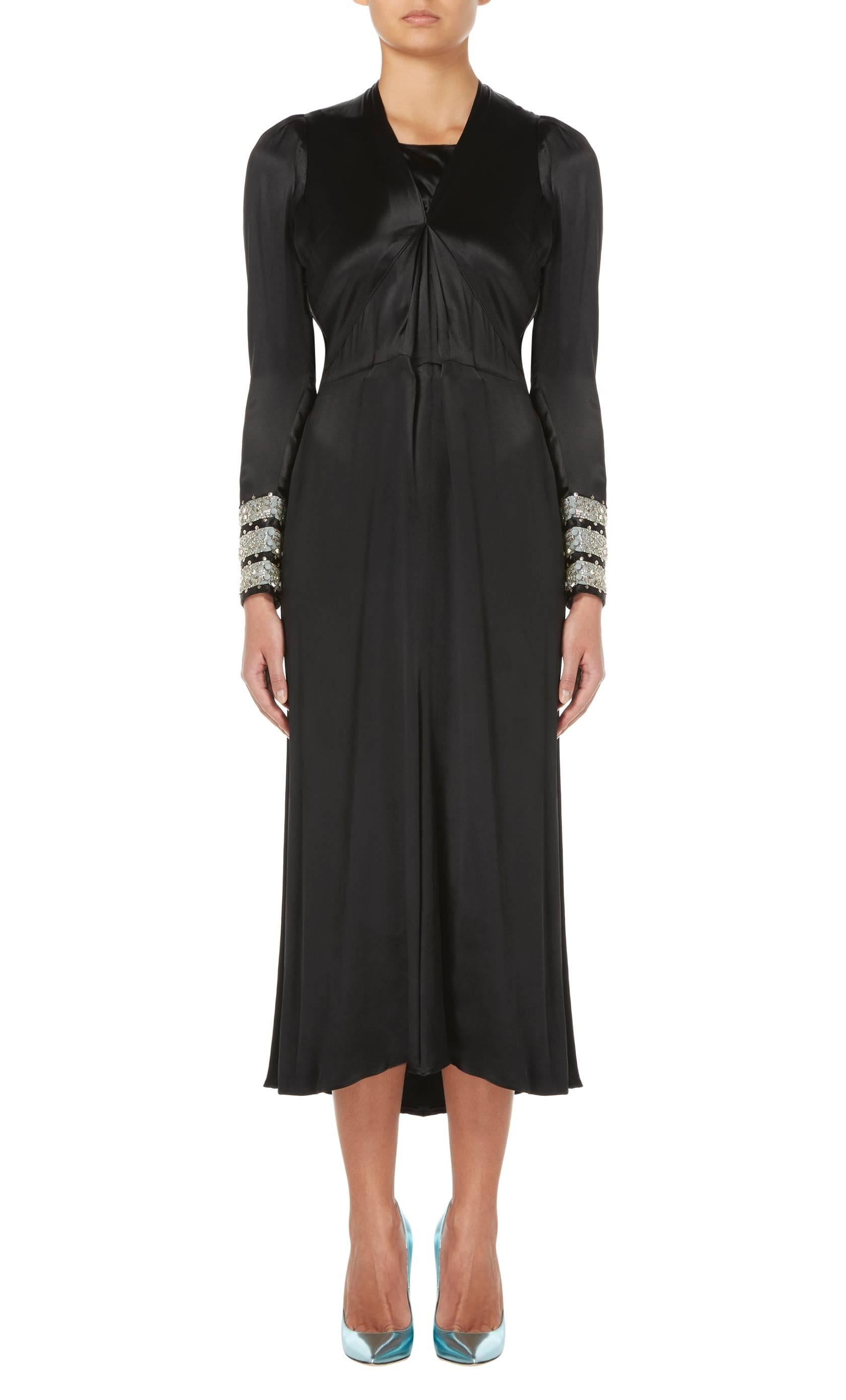 An incredible piece of Lanvin haute couture, this black silk dress is an elegant option for the red carpet or special occasion. The long sleeves are striped with powder blue silk around the cuffs and embellished with silver metallic thread and