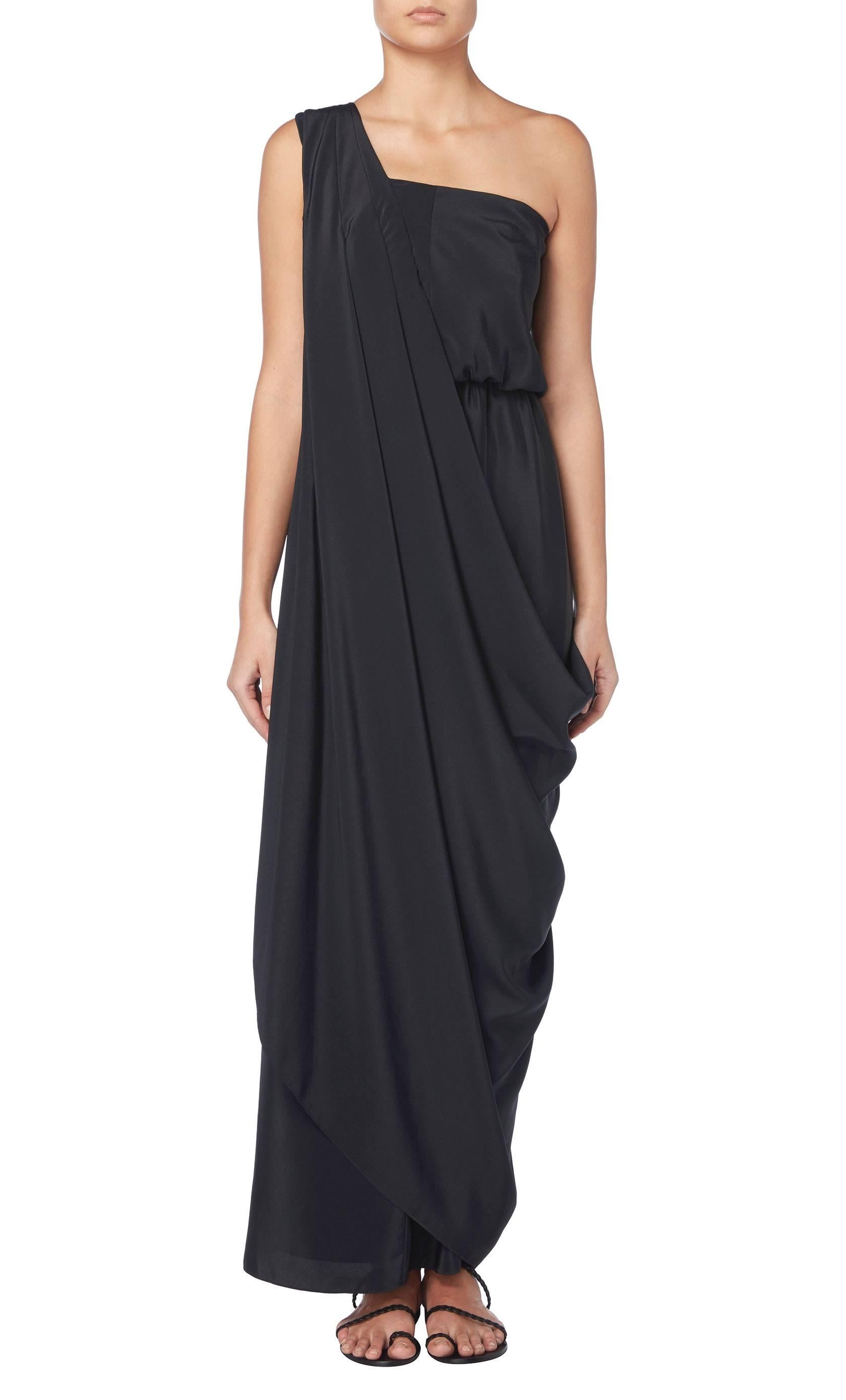 A prime example of Halston's fluid and luxurious vision, this glorious labyrinth draped dress is simultaneously chic and comfortable. Worn on one shoulder and crafted in elegant black silk crepe, the dress is extremely flattering and an ideal choice