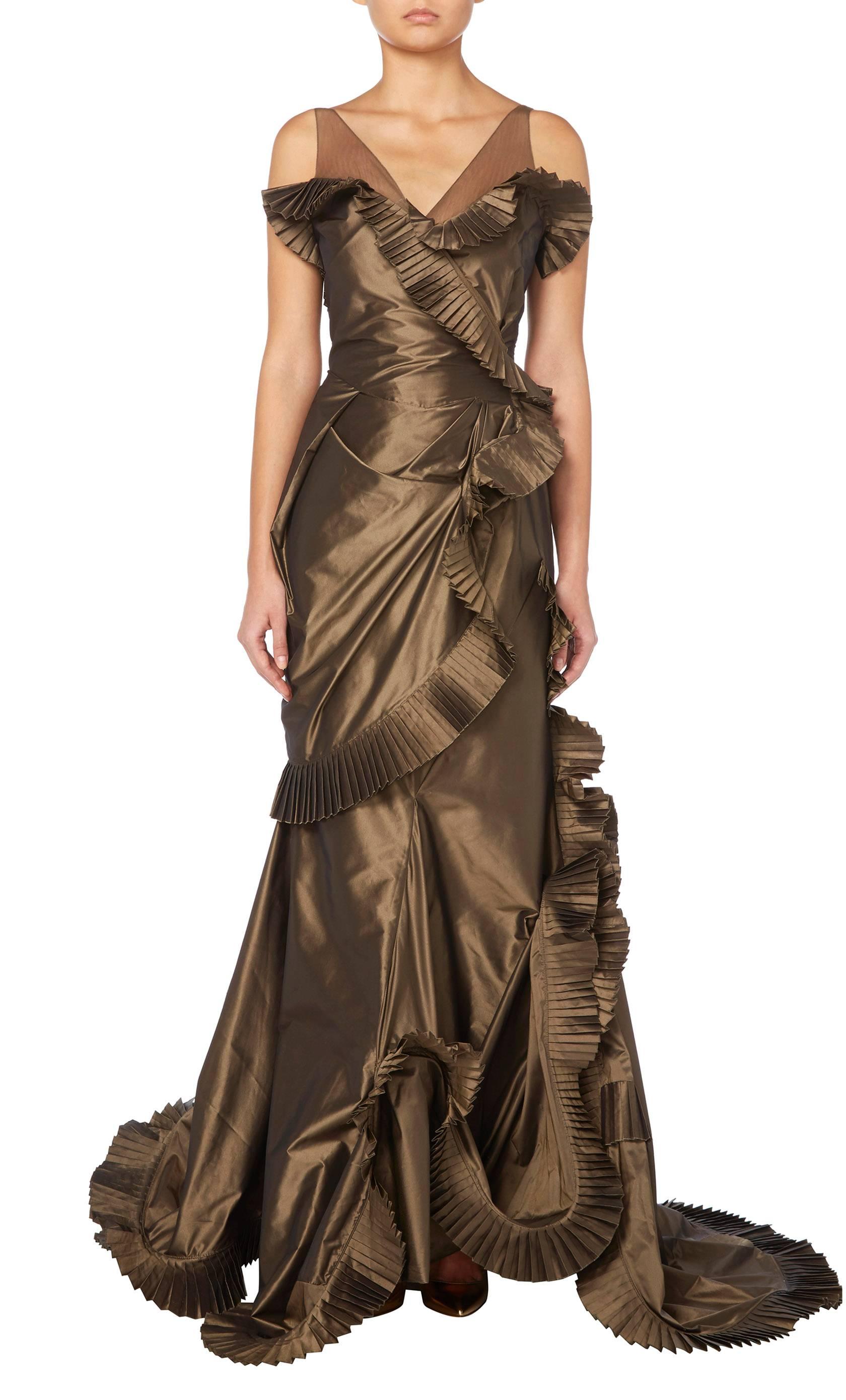 An eye-catching example of John Galliano for Christian Dior, this gown is constructed in brown silk taffeta and has a Far Eastern inspiration with its ruffled edging of micro-pleated silk taffeta and shoulder straps of bronze silk tulle.