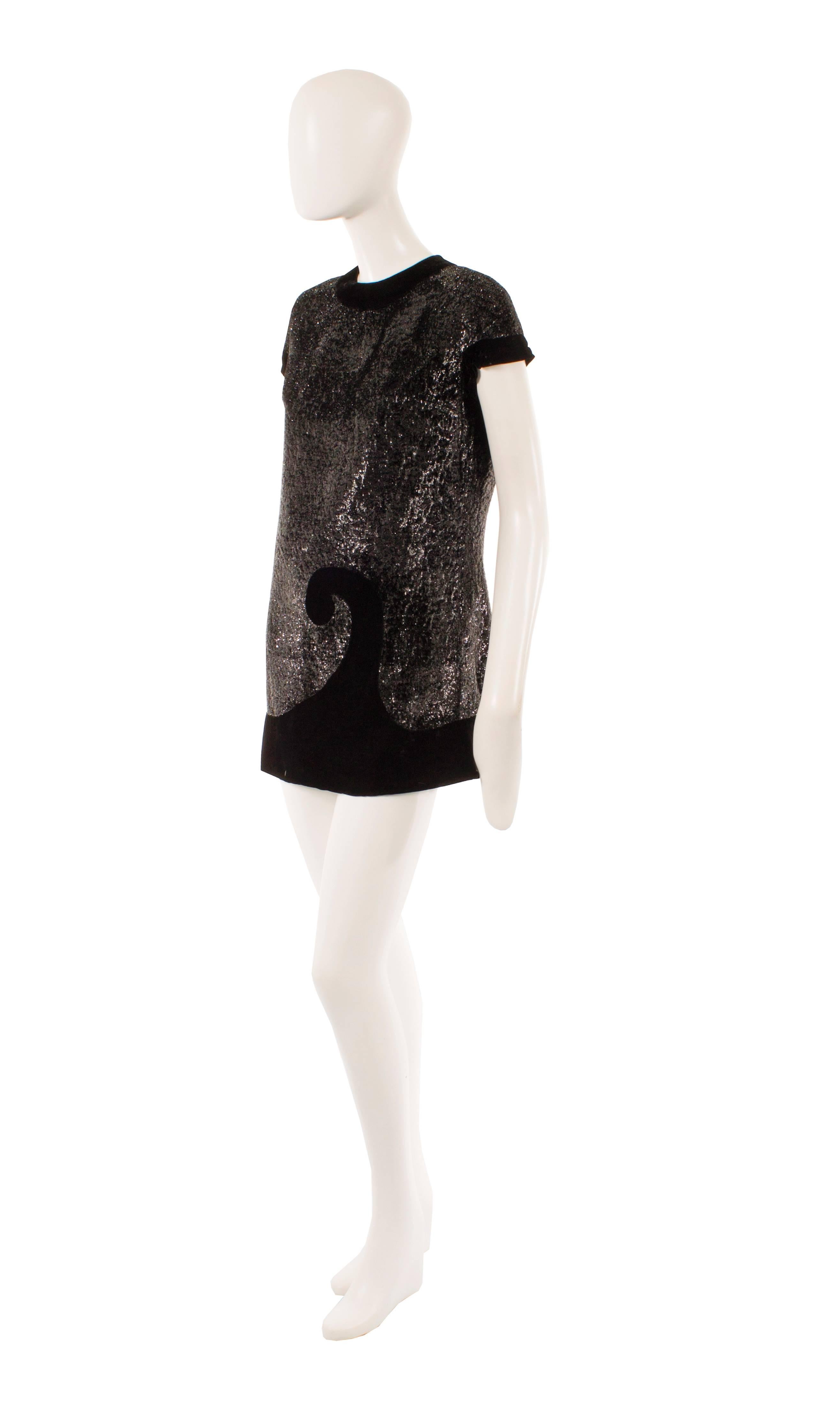 Super sexy, this Pierre Cardin mini dress is the perfect choice for a party! Constructed in black metallic Lurex, the dress features a contrasting black velvet trim around the neckline, sleeves and hem and forms a Cardin logo motif to the front. The